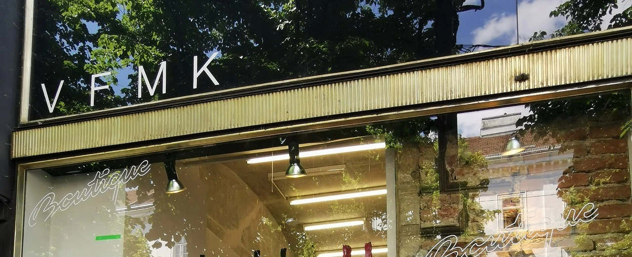 Moderne Boutique-Fassade mit goldenen Akzenten. VFMK.