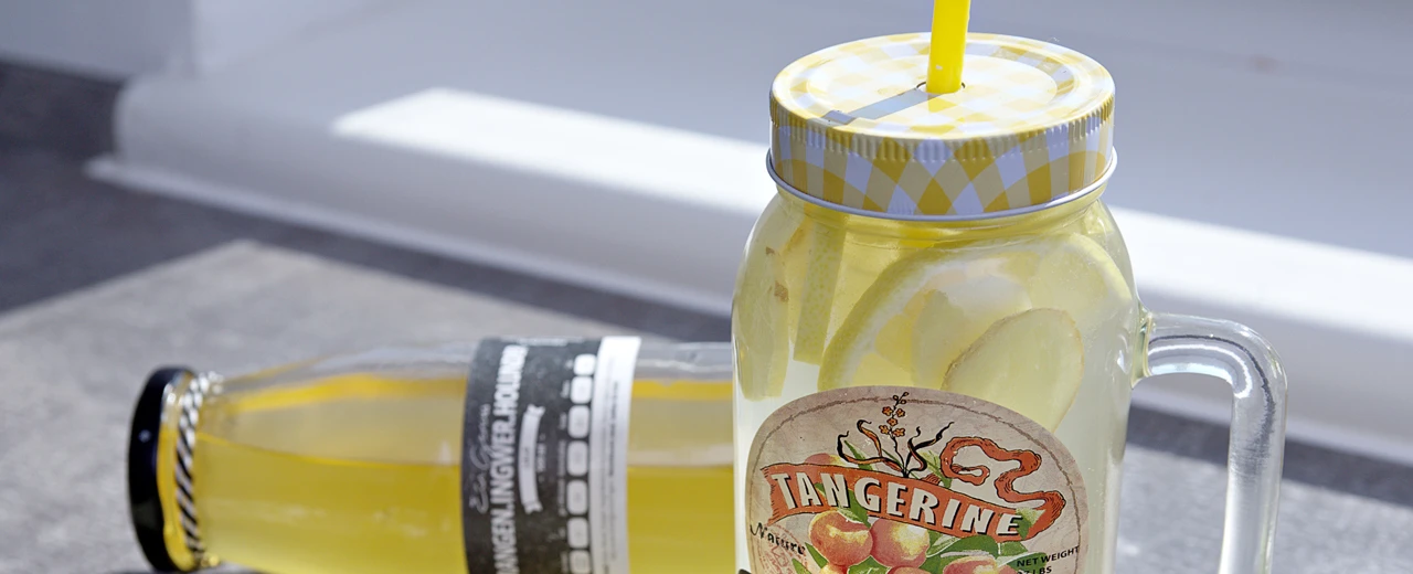 Glas mit erfrischendem Zitronen-Ingwer-Getränk, gelber Strohhalm, 