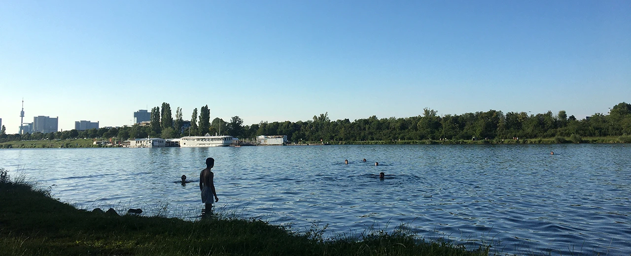 Menschen schwimmen in einem See an einem sonnigen Tag vor einer Stadtkulisse.  Erstellt mit Adobe Photoshop.