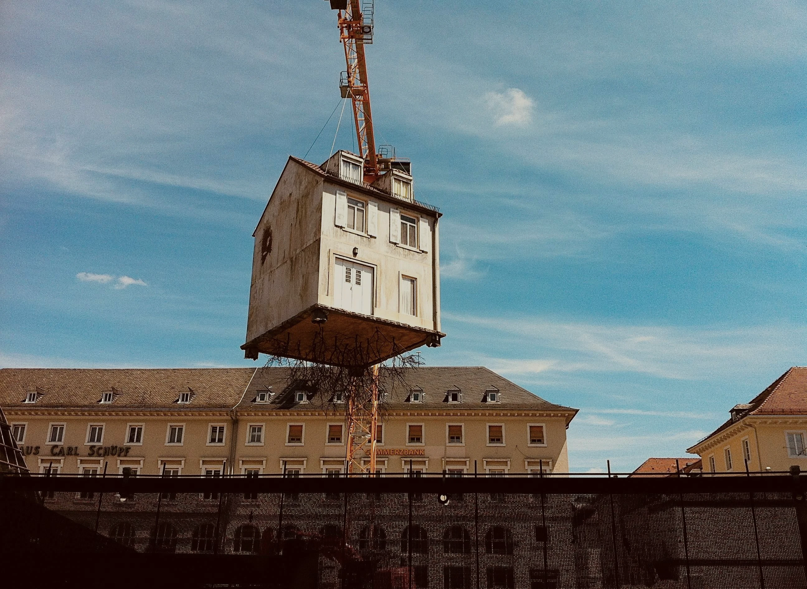 Altes Haus, das von einem Kran hängt