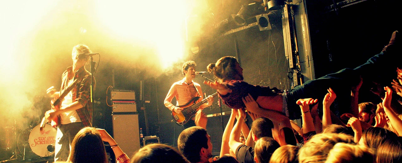 Band spielt auf der Bühne vor jubelndem Publikum. Beeindruckende Lichtshow.