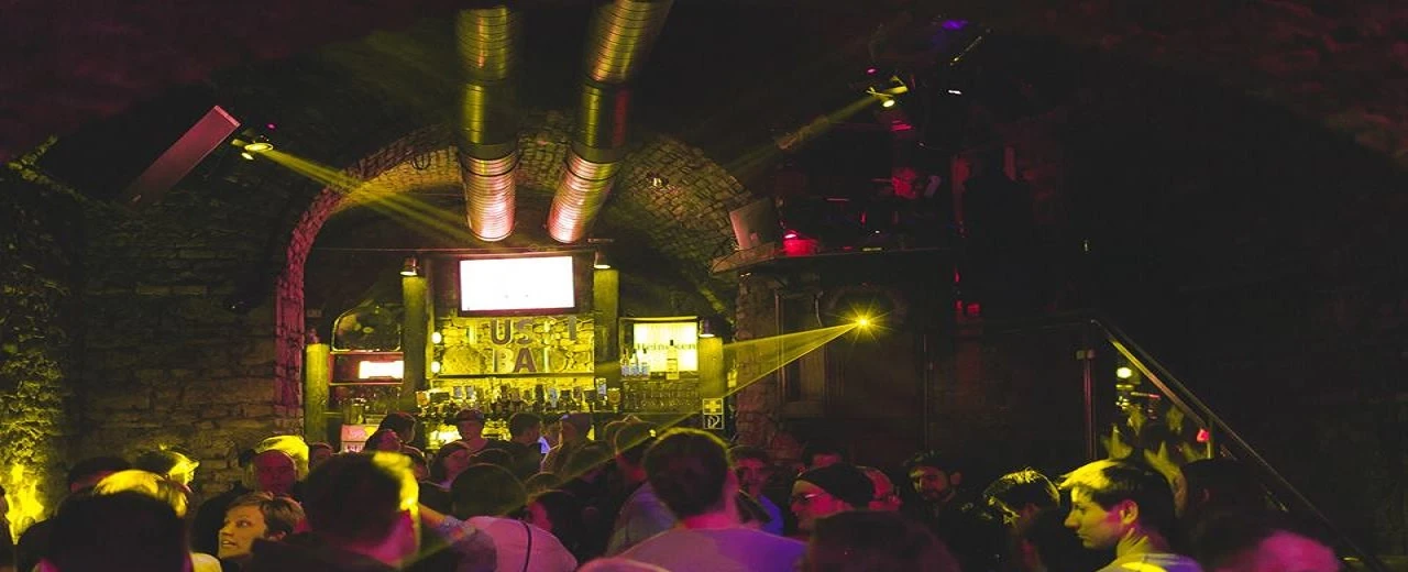 © MarzenaWolowicz_ViaFacebook Bild von Marzena Wolowicz:  Szene in einem beleuchteten Nachtclub mit Menschenmenge vor der Bar.