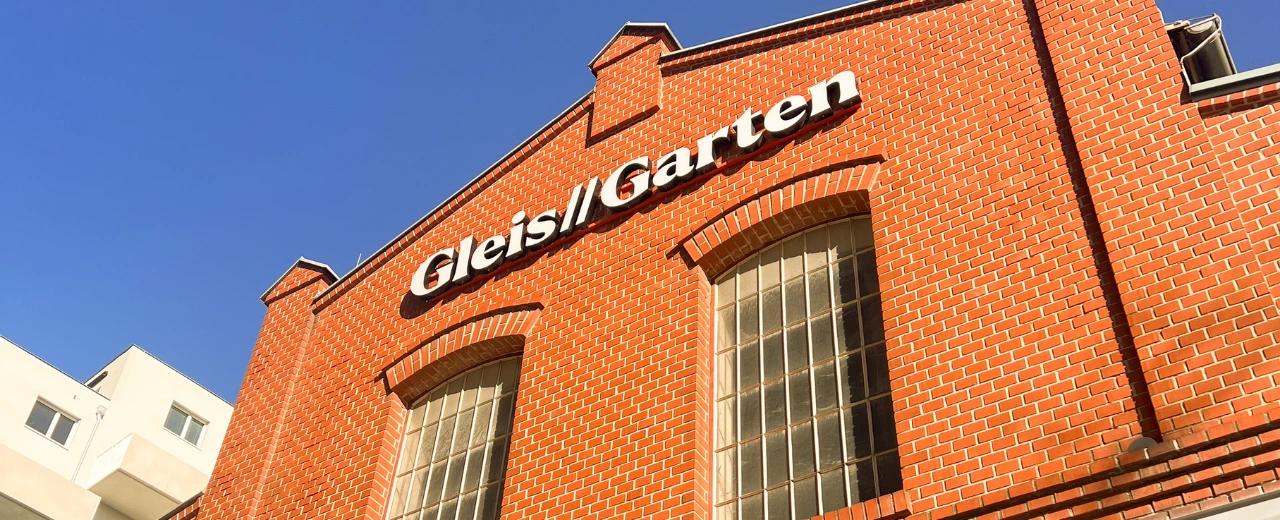 Gleis//Garten Gebäudeansicht: rote Backsteinfassade mit großem Schriftzug.