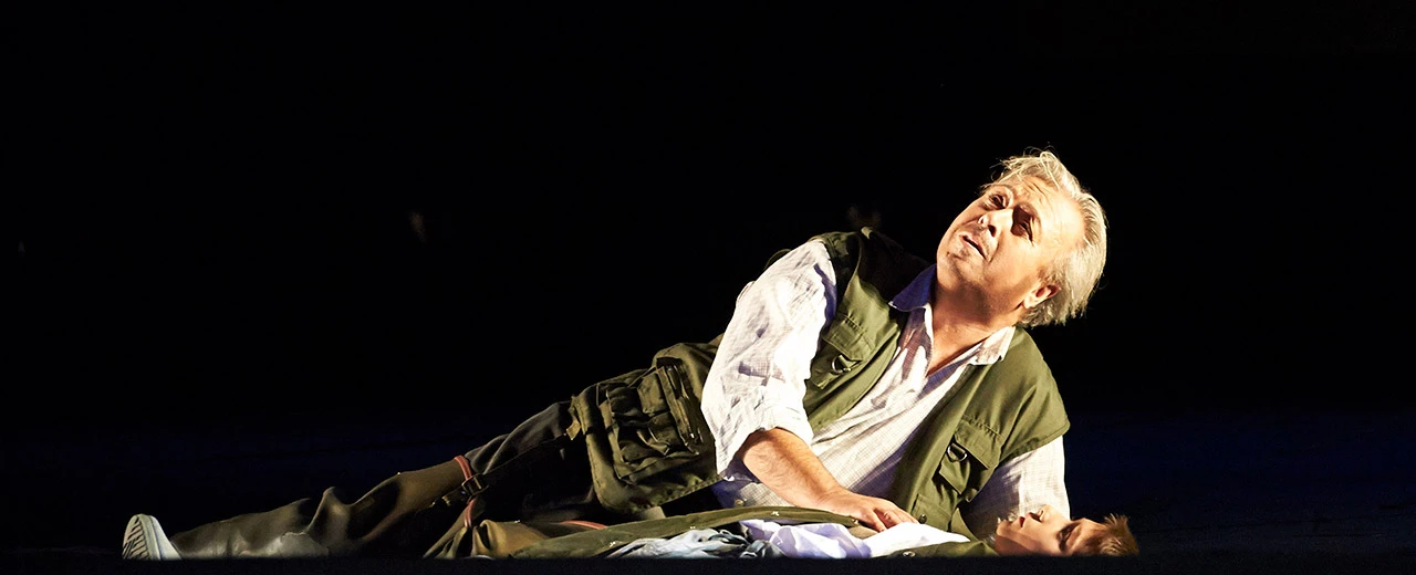 © O-MIA | Tenor Herbert Lippert Dramatische Szene einer Opernaufführung an der Wiener Staatsoper. Ein Mann beugt sich über eine am Boden liegende Person.