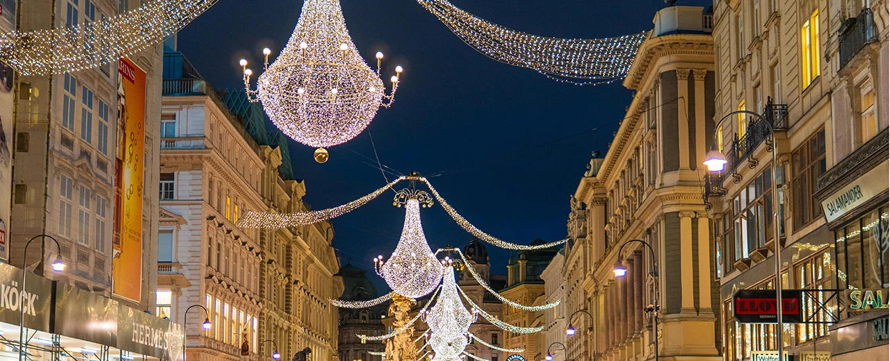 © Anna Gugerell Weihnachtlich beleuchtete Straße in Wien mit Kronleuchtern und Lichterketten. Schönes festliches Stadtbild.