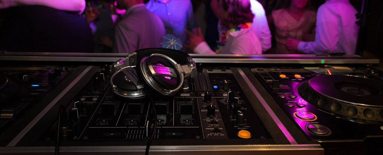 DJ-Kopfhörer und Mixer-Pult auf einer Party. Mit Adobe Photoshop bearbeitet.