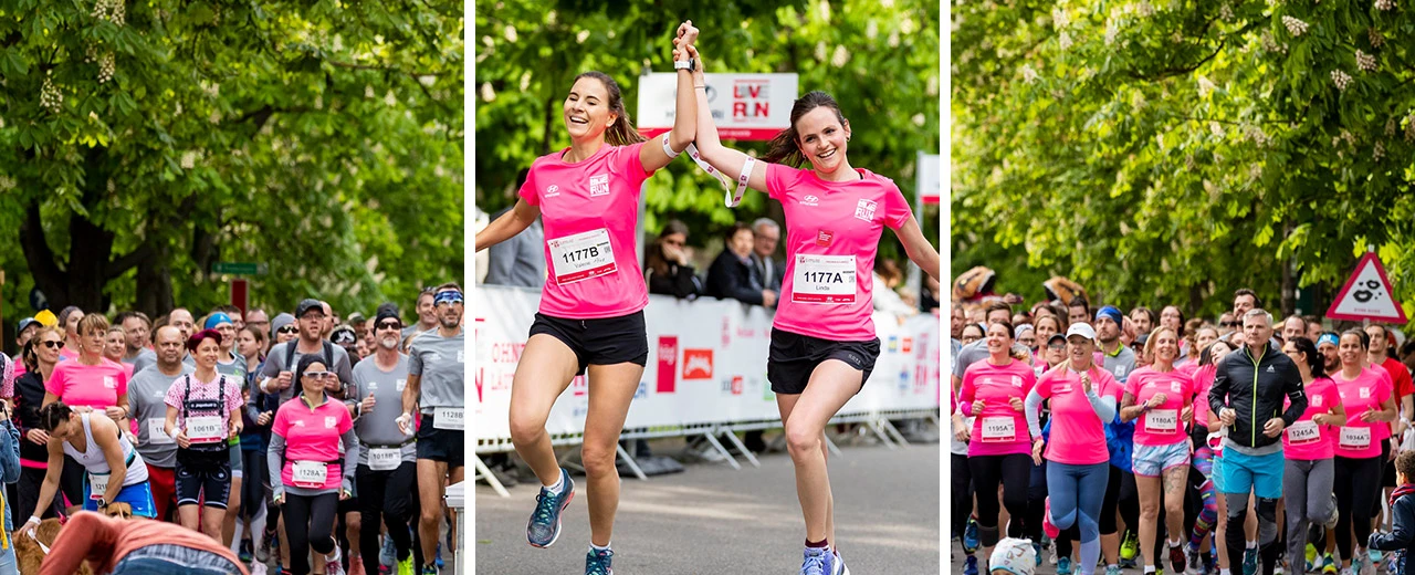 © Loverunvienna Zwei Läuferinnen in rosa Shirts überqueren bei einem Spendenlauf jubelnd die Ziellinie. Viele weitere Teilnehmer im Hintergrund.