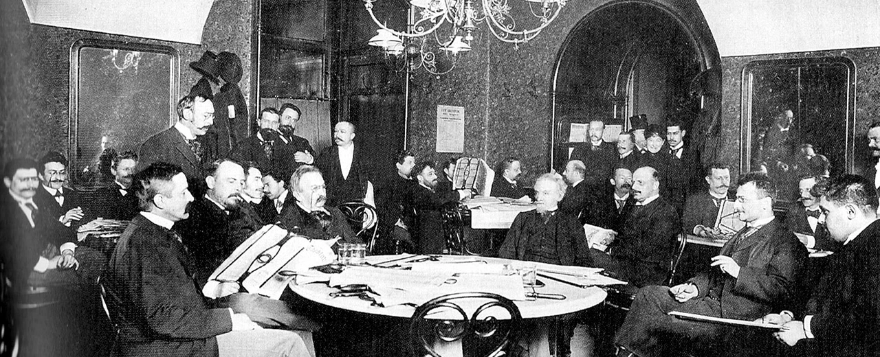 Historisches Foto: Männer in formeller Kleidung bei einer Konferenz um einen Tisch.