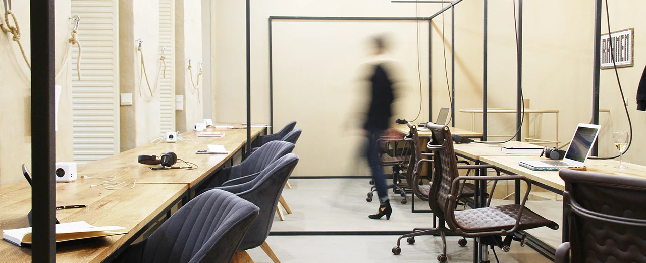 © Zimmer Nummer Acht Modernes Büro mit Holztischen, dunklen Stühlen und Laptops. Co-Working Space.