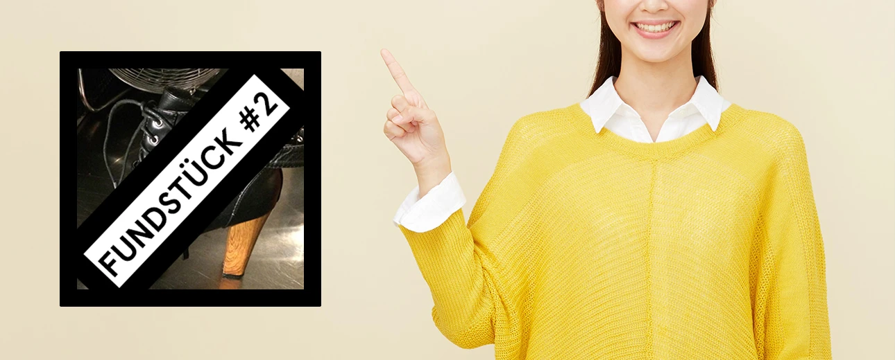 Frau zeigt auf ein Bild eines gefundenen schwarzen Damenschuhes mit Holzabsatz (Fundstück #2).