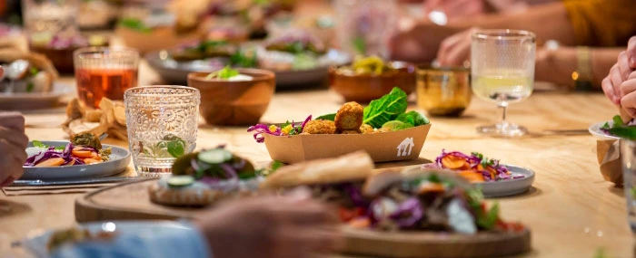 Gemütliche Tischszene mit verschiedenen Gerichten wie Falafel, Salaten und Brot.  Perfekt für Food-Blogs, Restaurants und Catering.