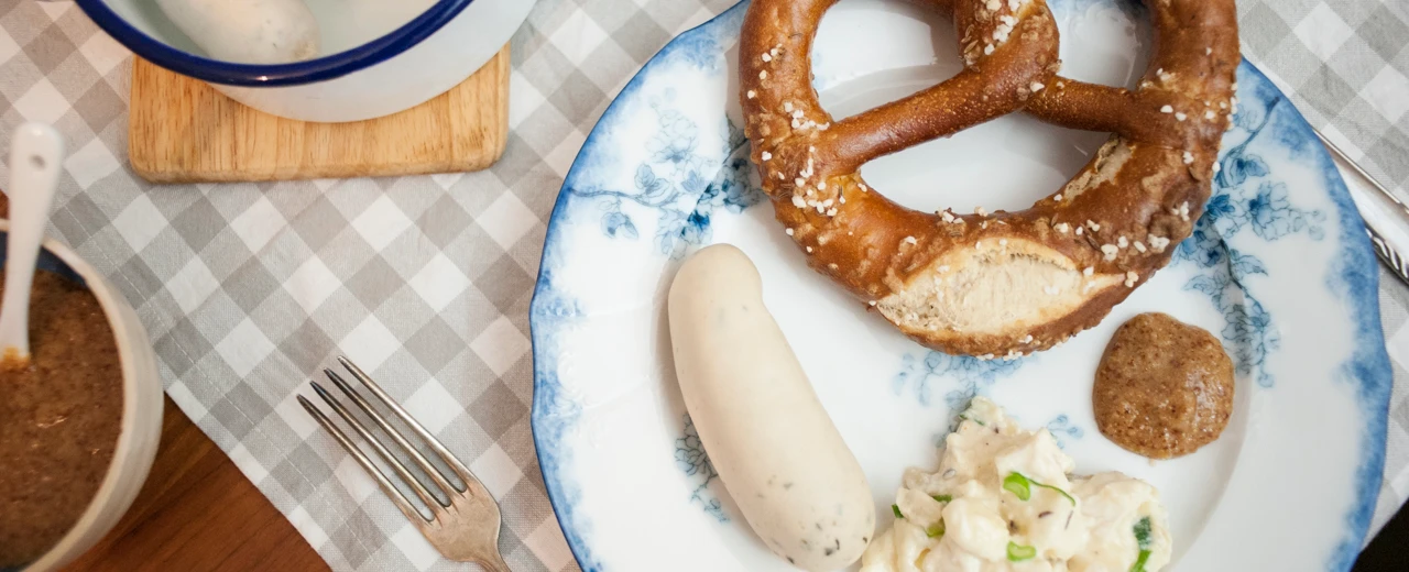 © youarehungry.com Bayerisches Frühstück: Weißwurst, Brezel, Kartoffelsalat & Senf auf blau-weißem Teller. Foto © Benedikt Steinle