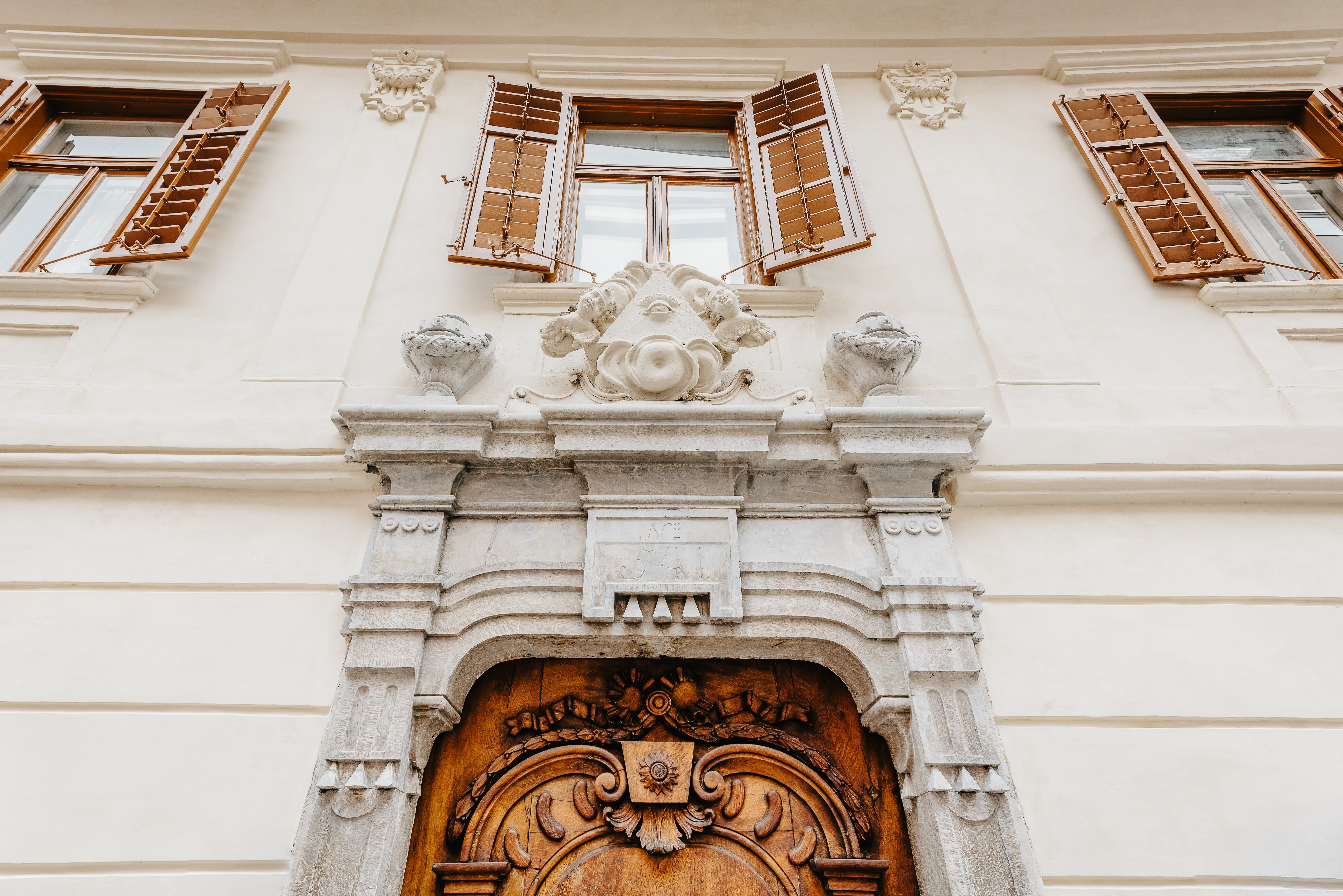 Fassade Altbau Wohninvestment Graz mit kunstvoller Holztüre