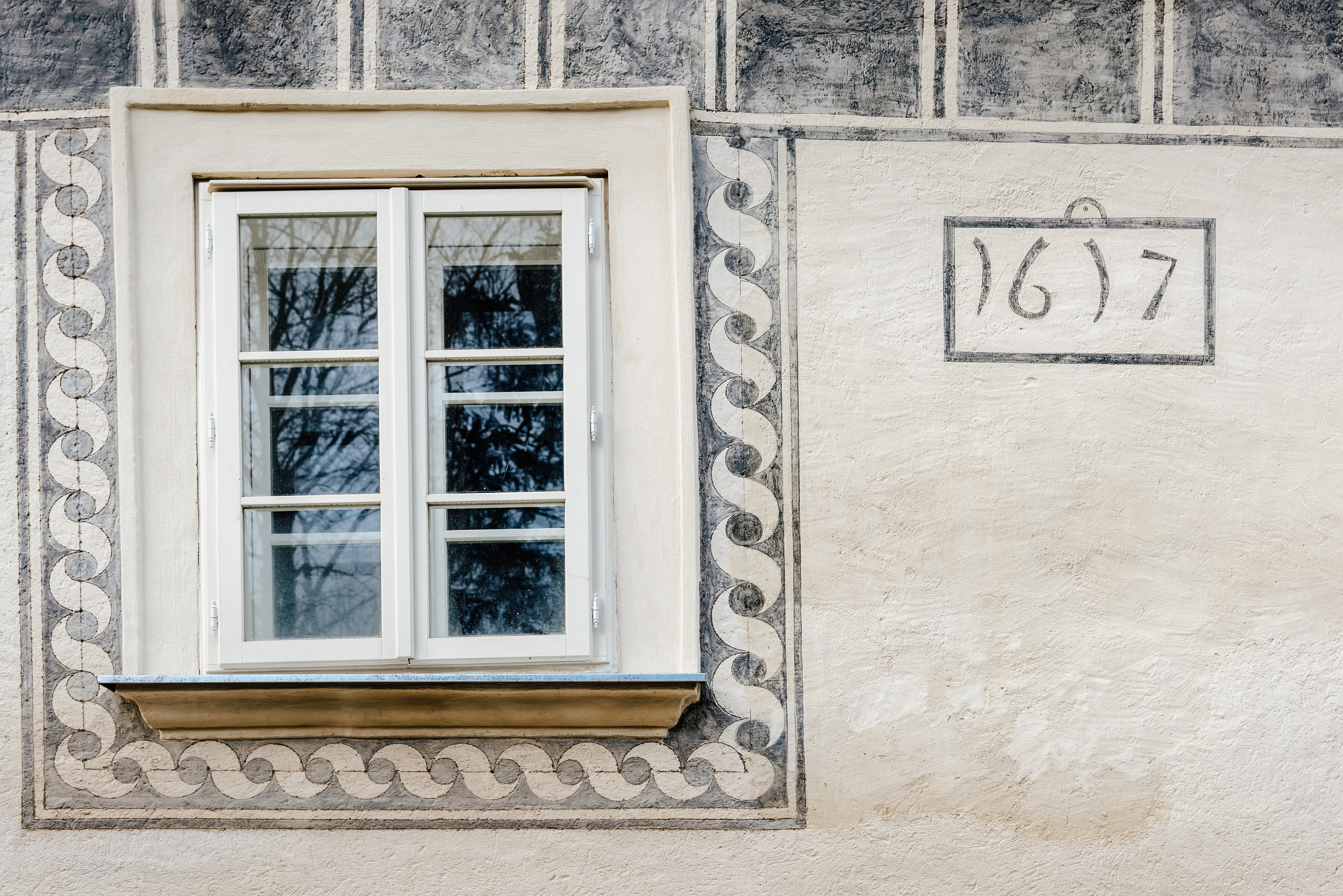 Kunstvoll bemaltes altes Fenster mit Jahreszahl 1617