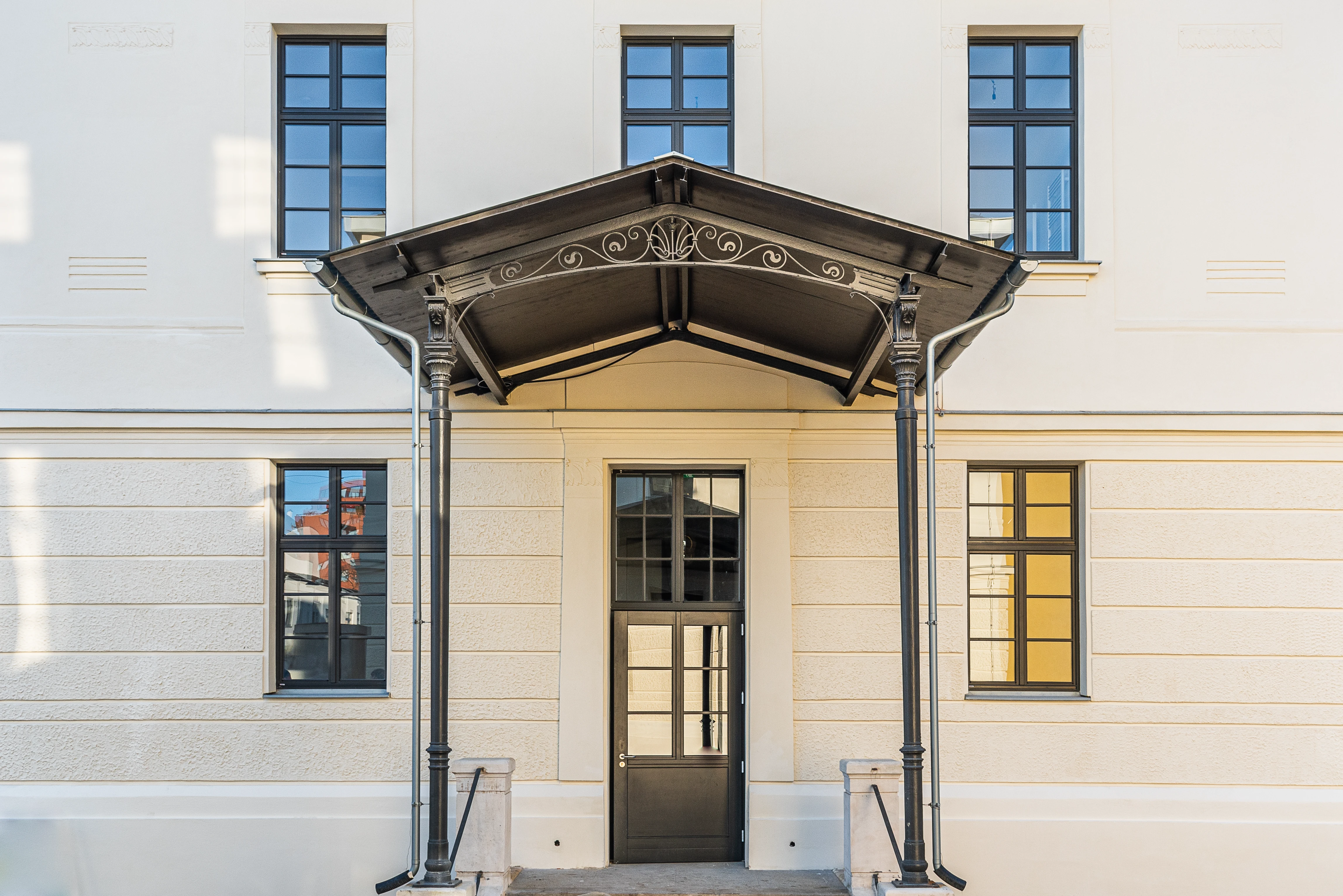 Schwarz überdachter Eingang des Bauherrenmodells Montleartstraße 1a von wohninvest