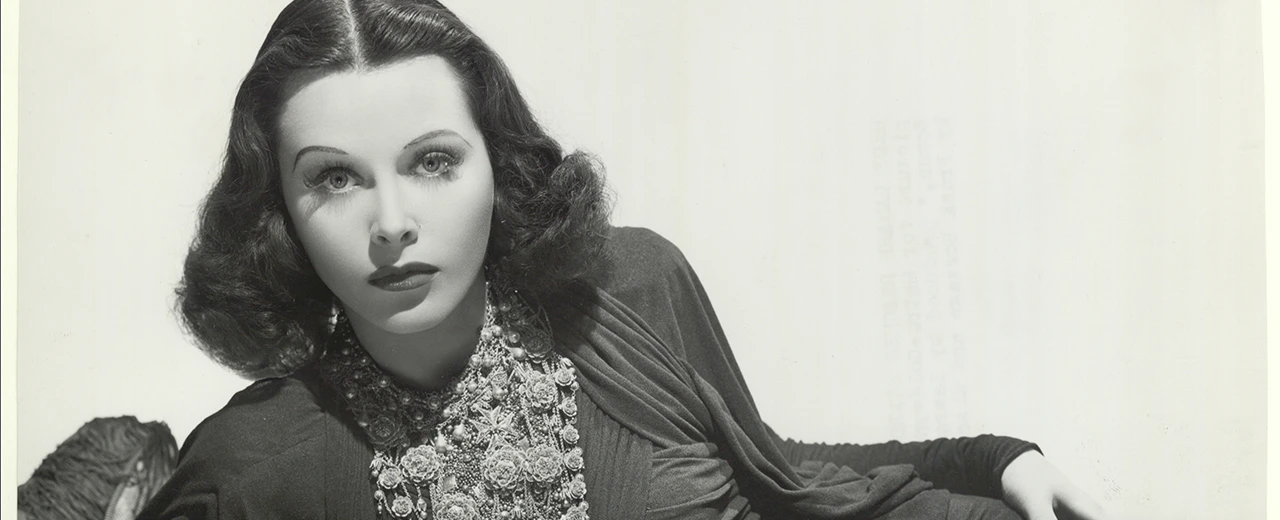 © Jüdisches Museum Wien Schwarz-Weiß-Porträt von Hedy Lamarr, Schauspielerin der goldenen Ära Hollywoods, mit auffälligem Schmuck.