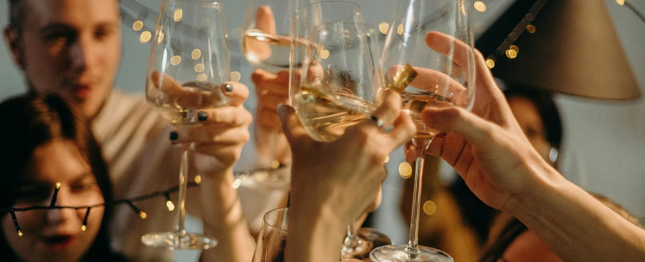 Freunde stoßen mit Weingläsern an. Gemütliche Afterwork-Atmosphäre.