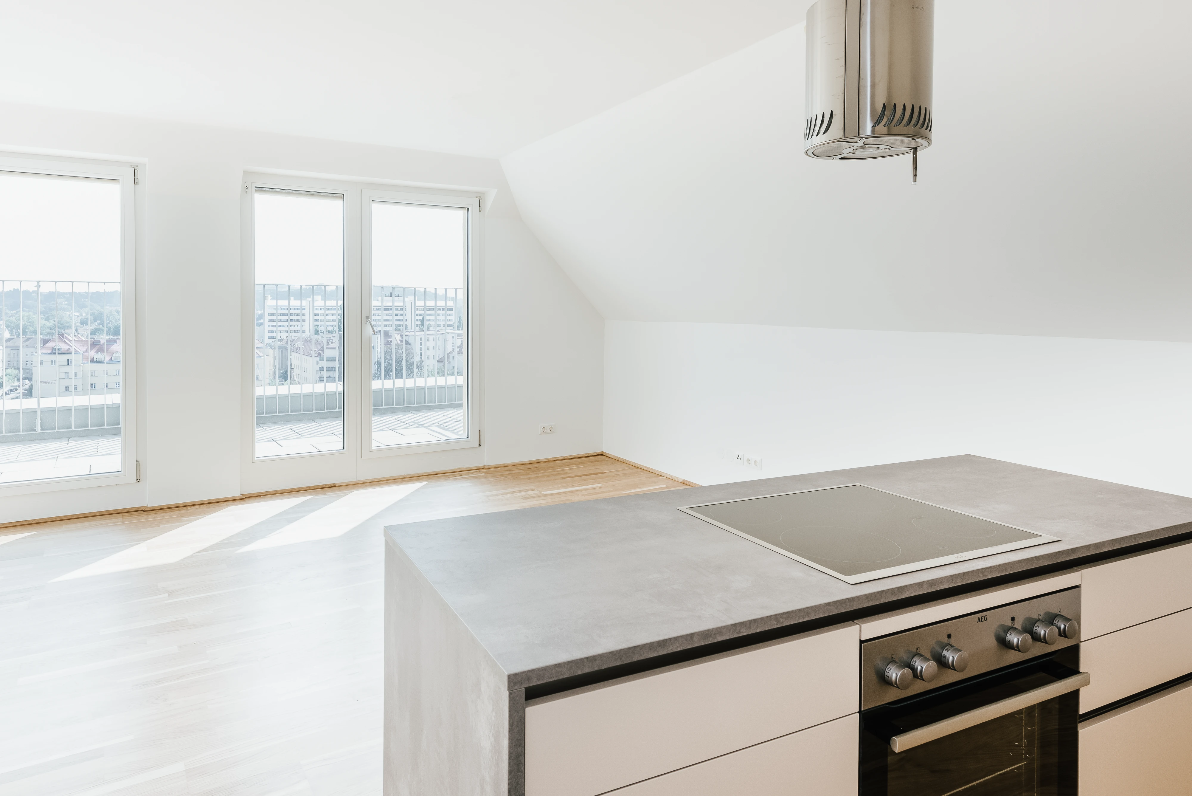Moderne Kücheninsel mit dunkelgrauer Arbeitsplatte und Blick auf die Stadt