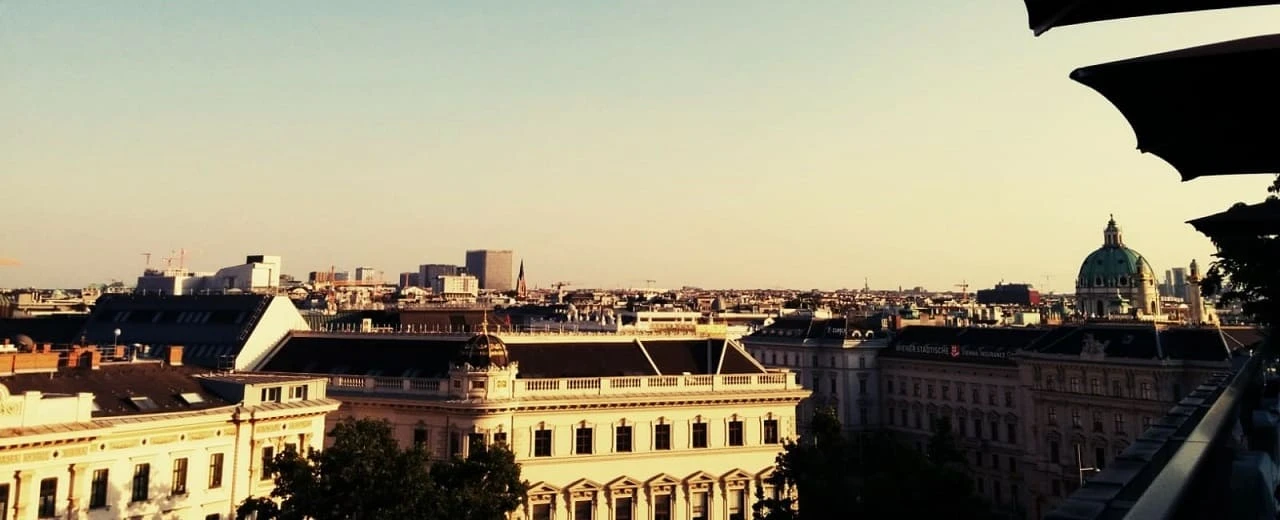 Atemberaubende Aussicht auf Wien bei Sonnenuntergang: historische Gebäude, Karlskirche & Skyline.