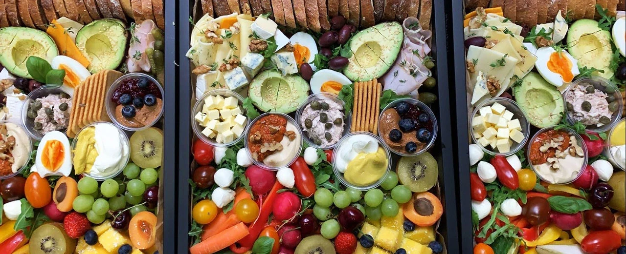 © Brotkost Drei gedeckte Snack-Boxen mit Käse, Obst, Gemüse, Aufstrichen und Brot. Perfekt für Partys oder Büro.