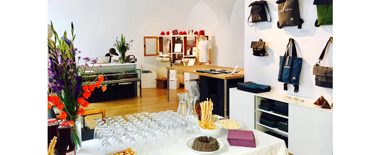 Heller, moderner Showroom mit Taschen, Snacks & Getränken. Minimalistisches Design.