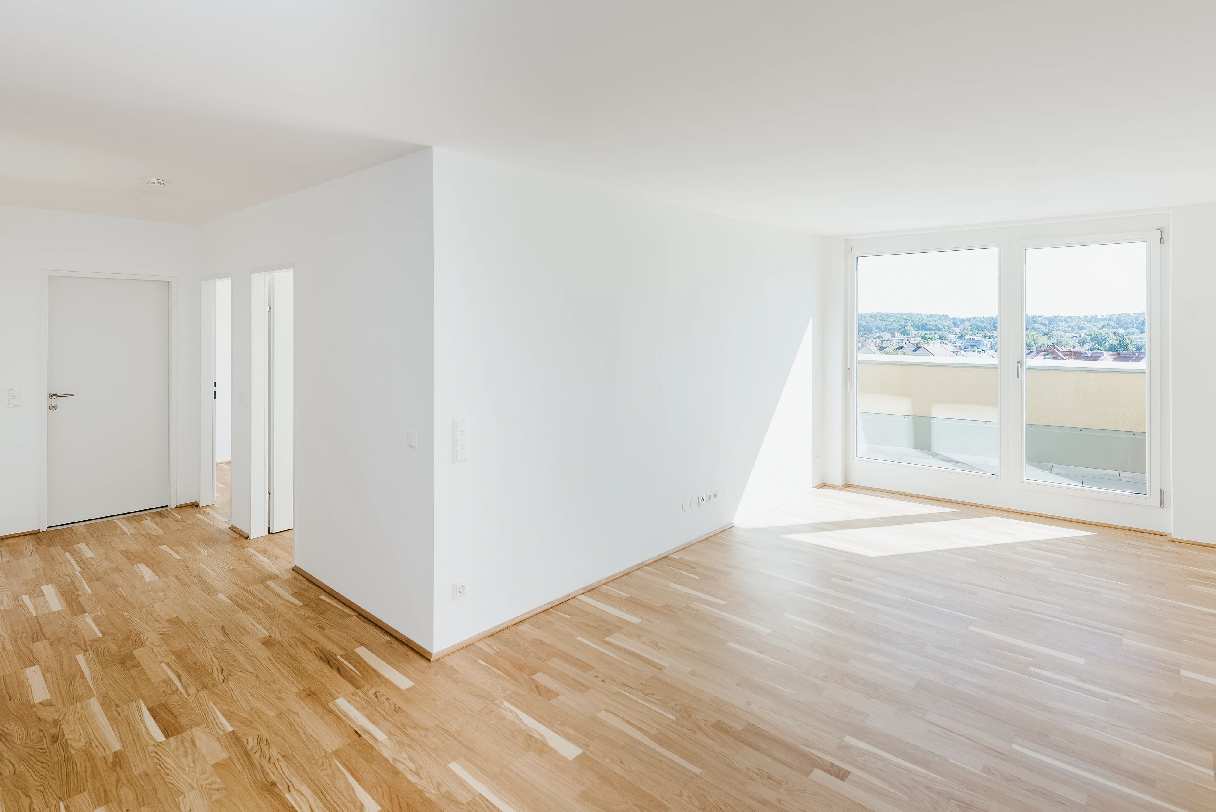 Modernes Wohninvestment aus Wohnzimmersicht mit Blick auf Balkon