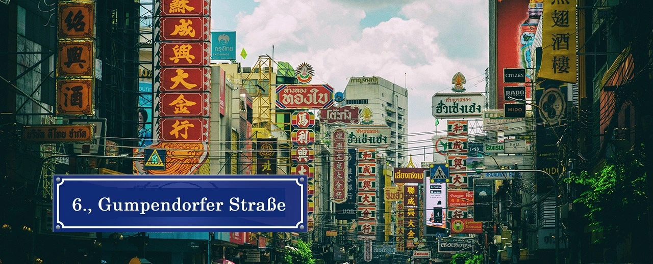 © Photo by Waranont Wichittranont on Unsplash Lebhafte Straße in Bangkok mit vielen Schildern in Thai und Chinesisch.  Fotografiert in einem Stil, der an Vintage-Filmfotografie erinnert.