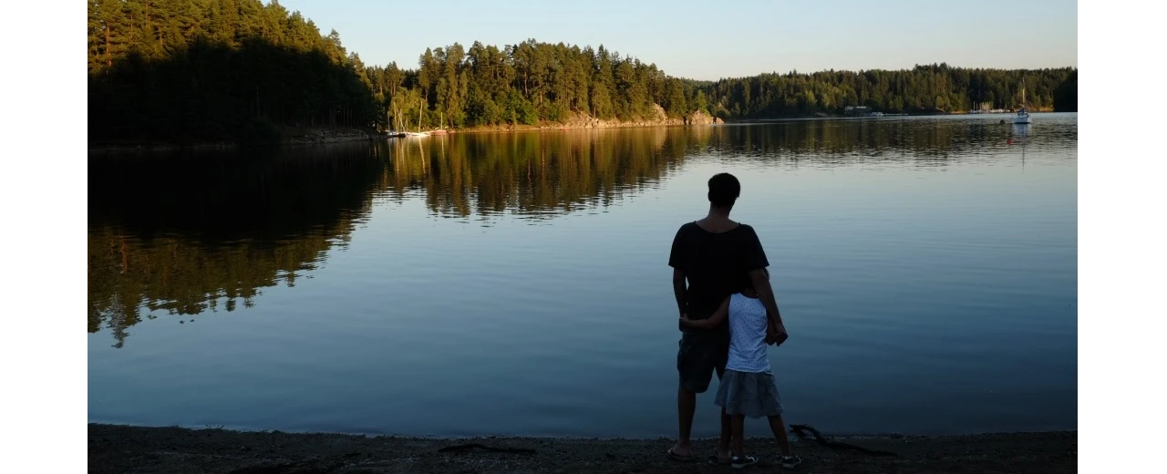 © Miriam Kummer Vater & Tochter am See bei Sonnenuntergang. Friedliche Naturlandschaft mit Spiegelung.