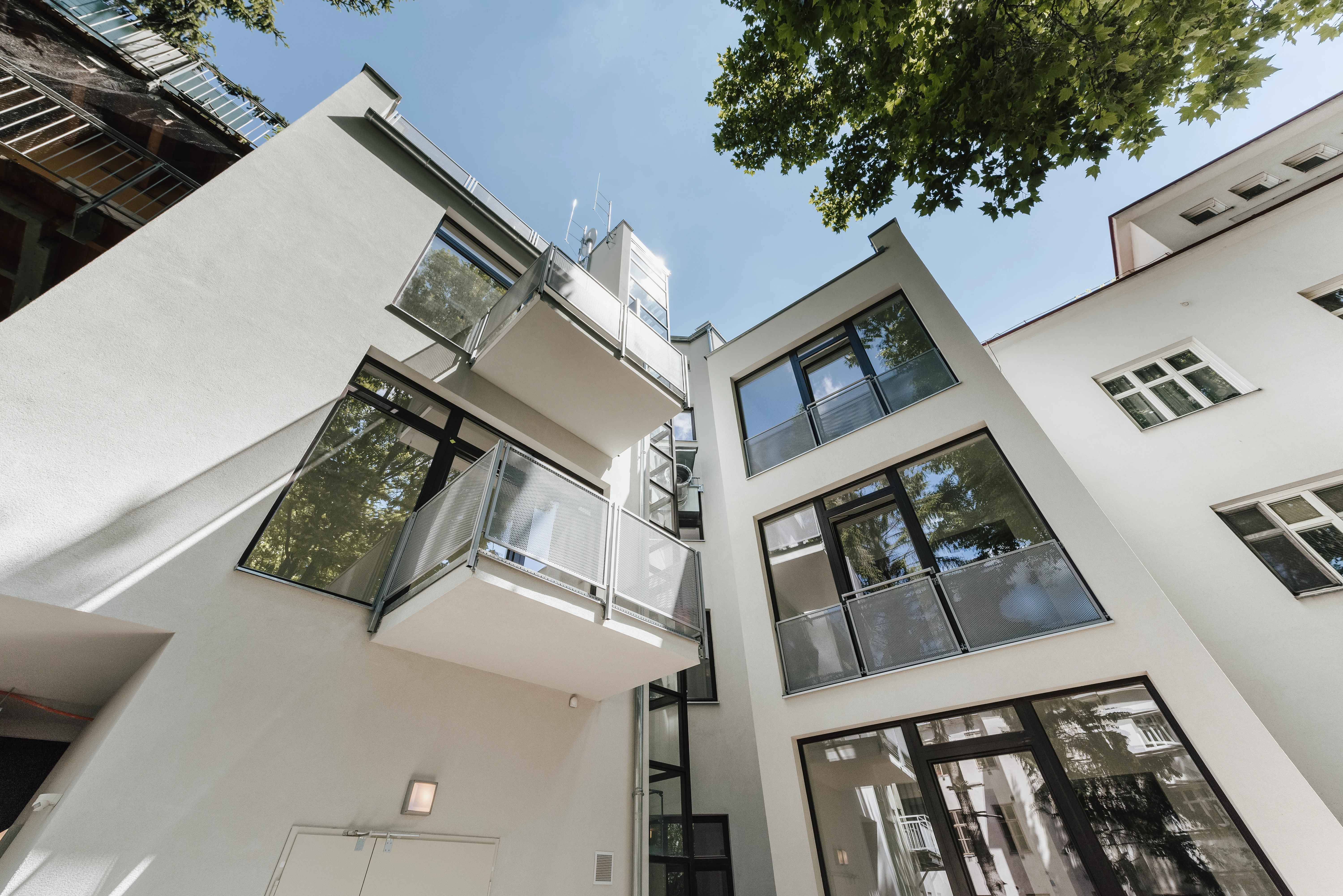 Außenansicht des Wohninvestments aus Innenhof auf Fenster und Balkone