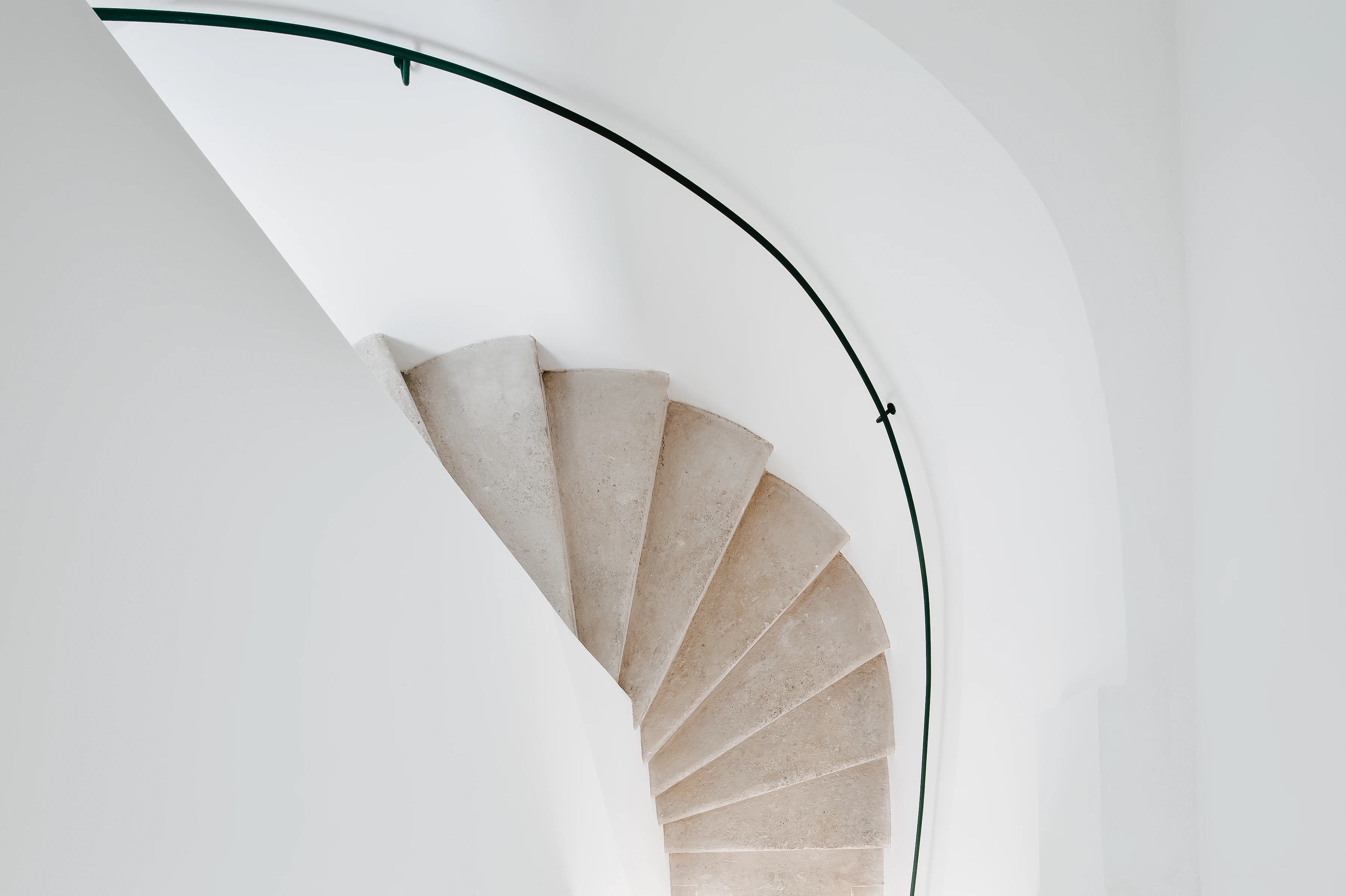 Heller Wendeltreppen Stiegenaufgang mit feinem schwarzen Metallhaltegriff