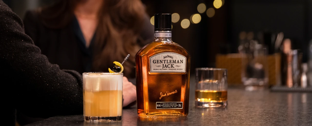 Jack Daniels Gentleman Jack Whiskey Flasche und Cocktail auf Bar.