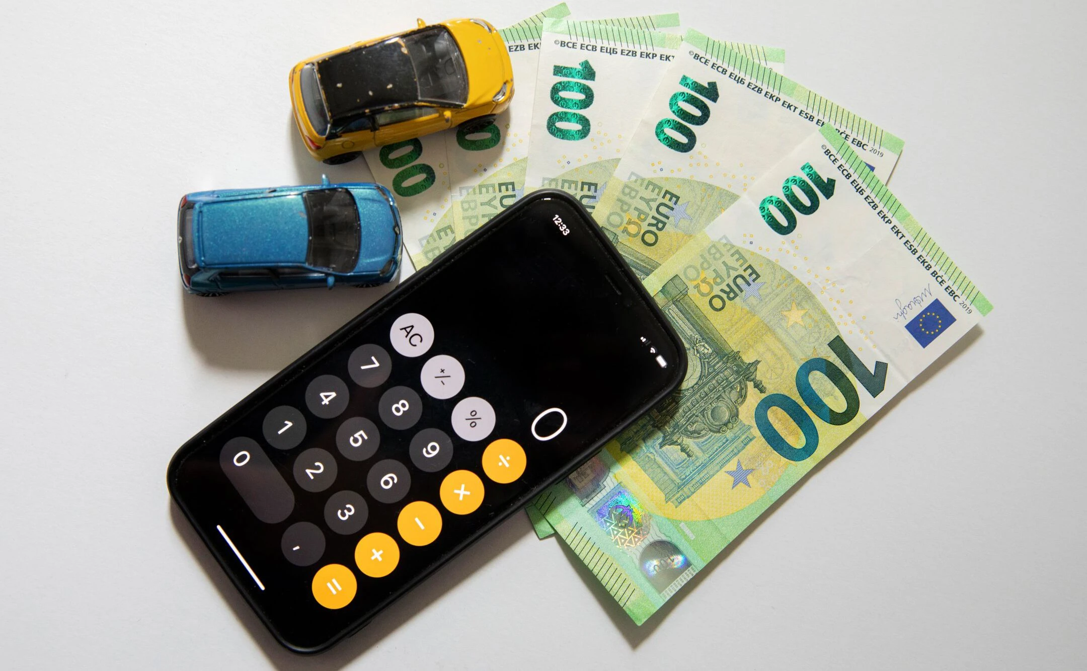 Taschenrechner, Geldscheine und Spielzeugautos