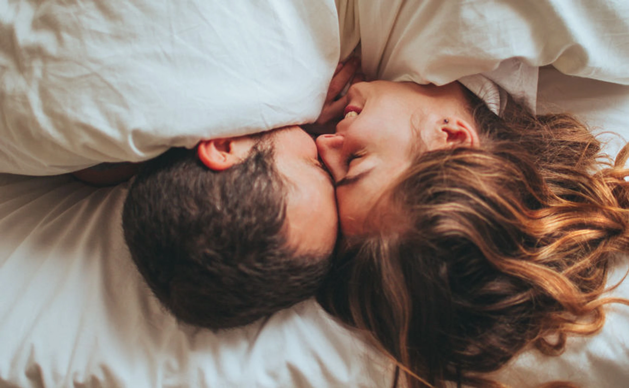 Frau und Mann, die im Bett kuscheln