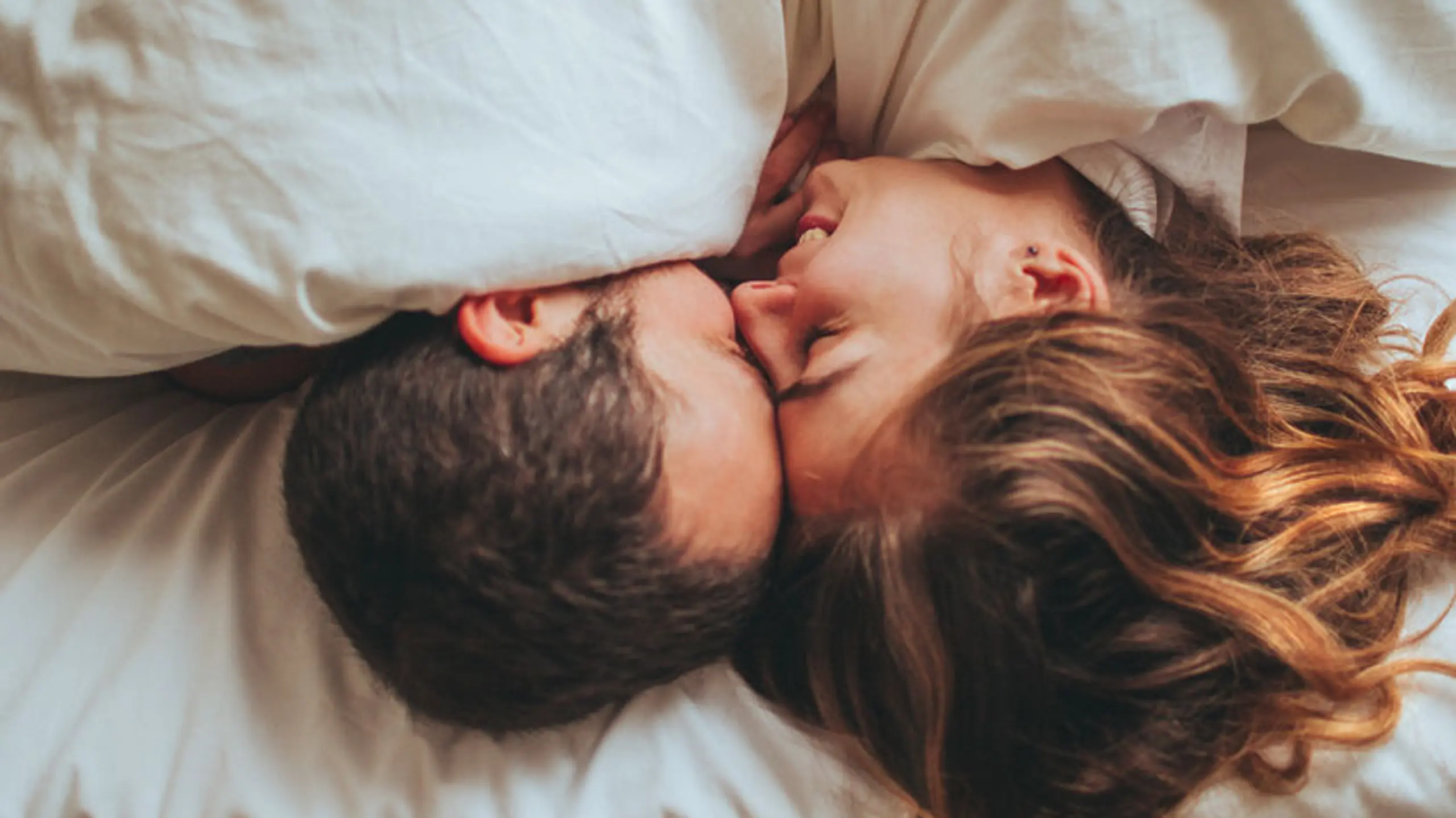 Frau und Mann, die im Bett kuscheln