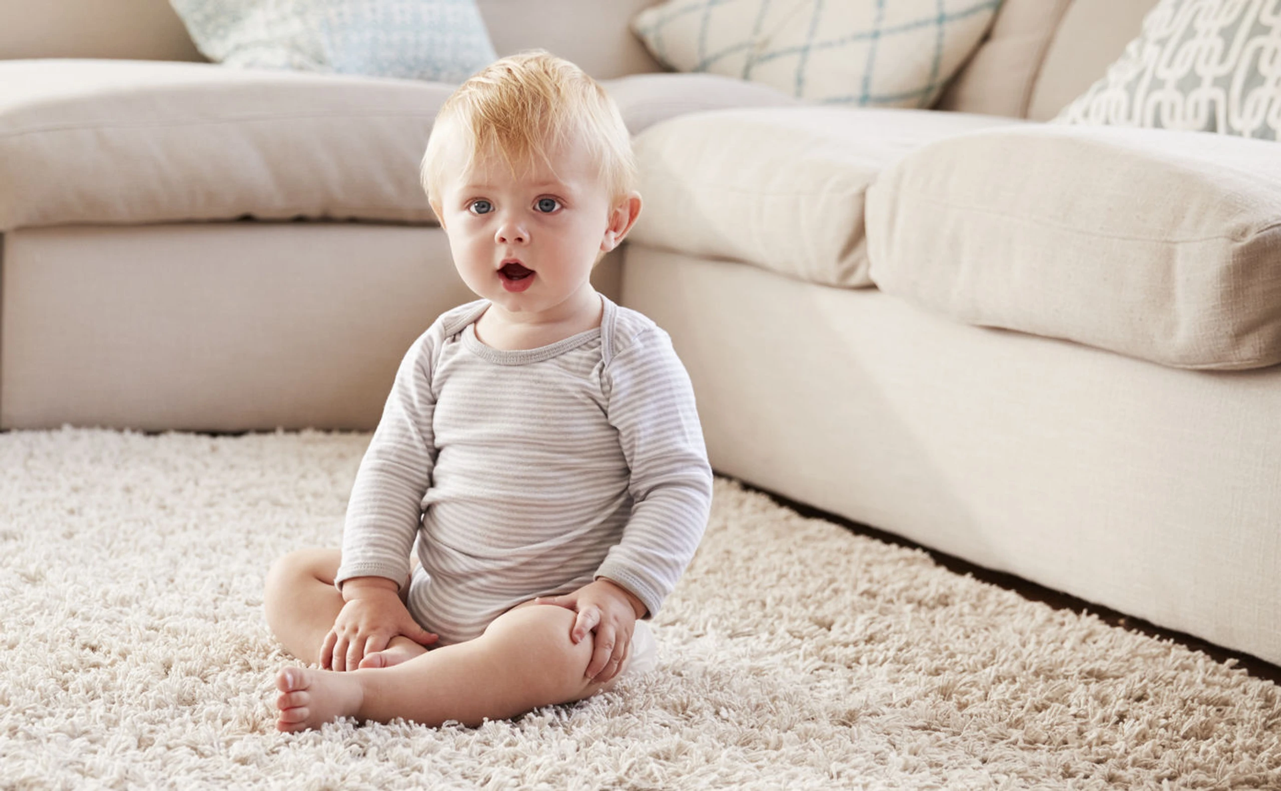 Baby, das auf einem Teppich sitzt