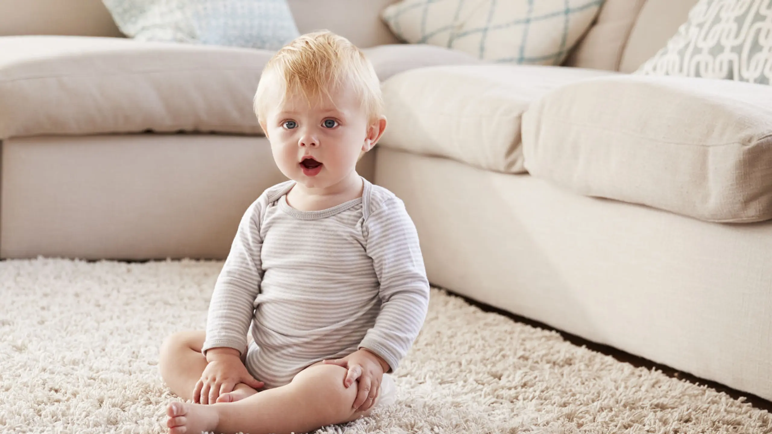Baby, das auf einem Teppich sitzt