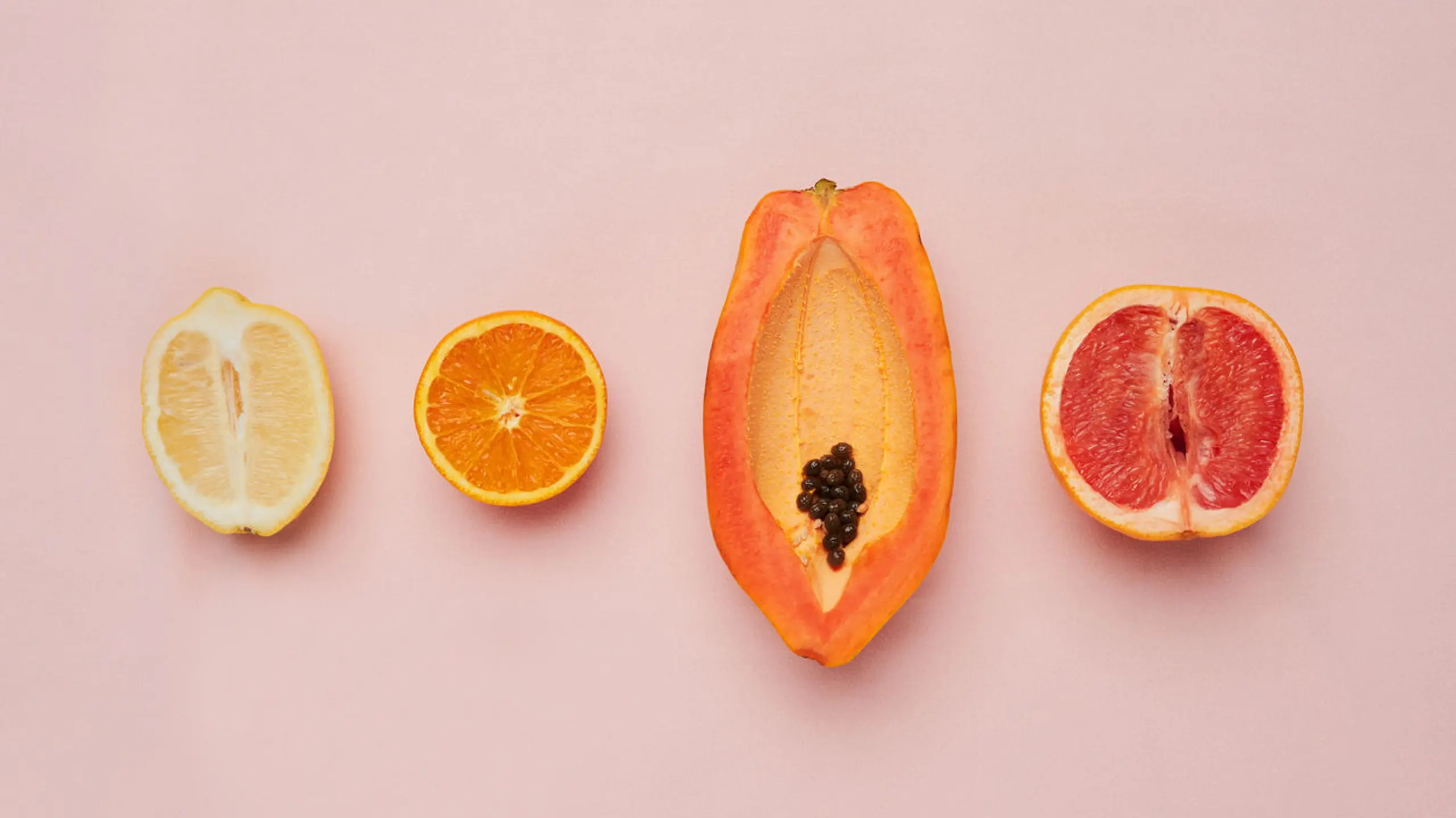 Aufgeschnittene Früchte auf einem rosa Hintergrund