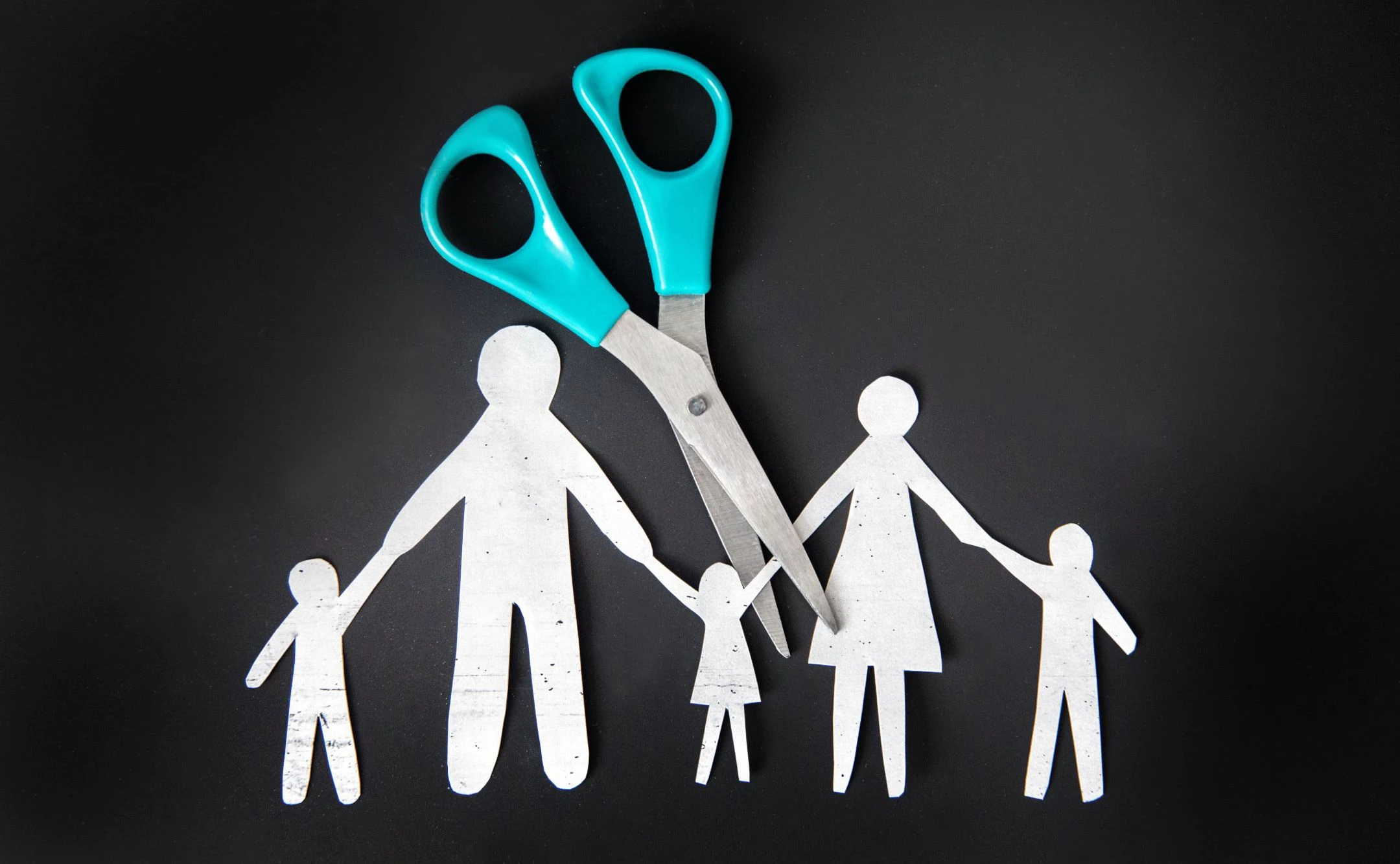 Familie aus Papier wird auseinandergeschnitten.