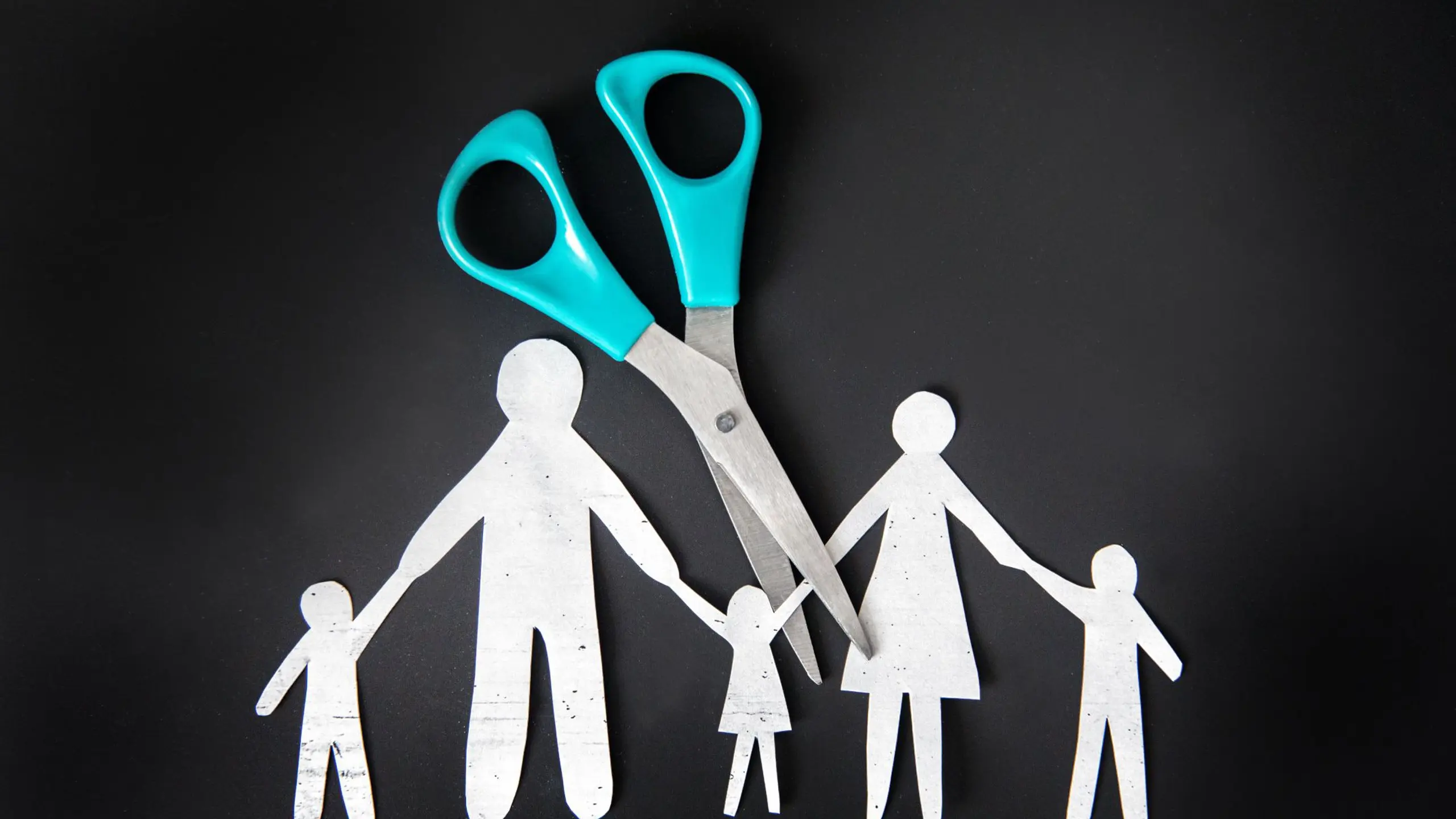 Familie aus Papier wird auseinandergeschnitten.