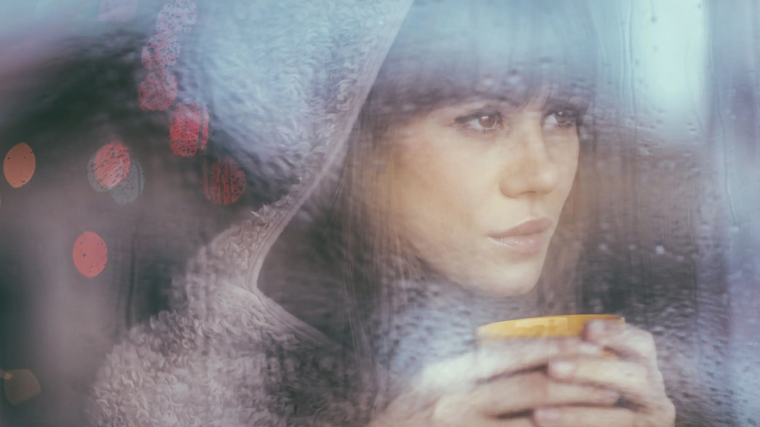 Frau, die nachdenklich aus einem Fenster schaut