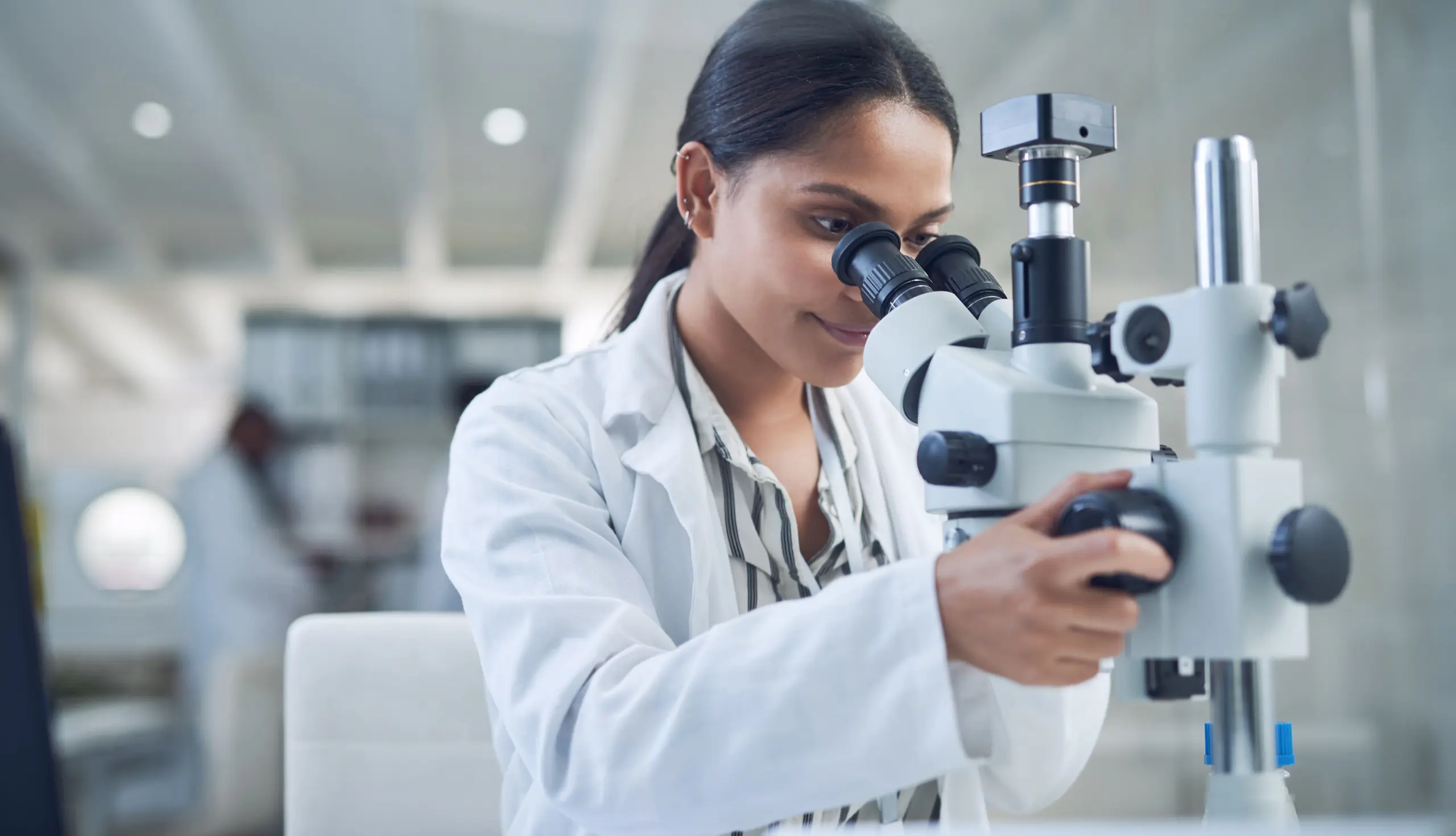 Pathologin arbeitet am Mikroskop