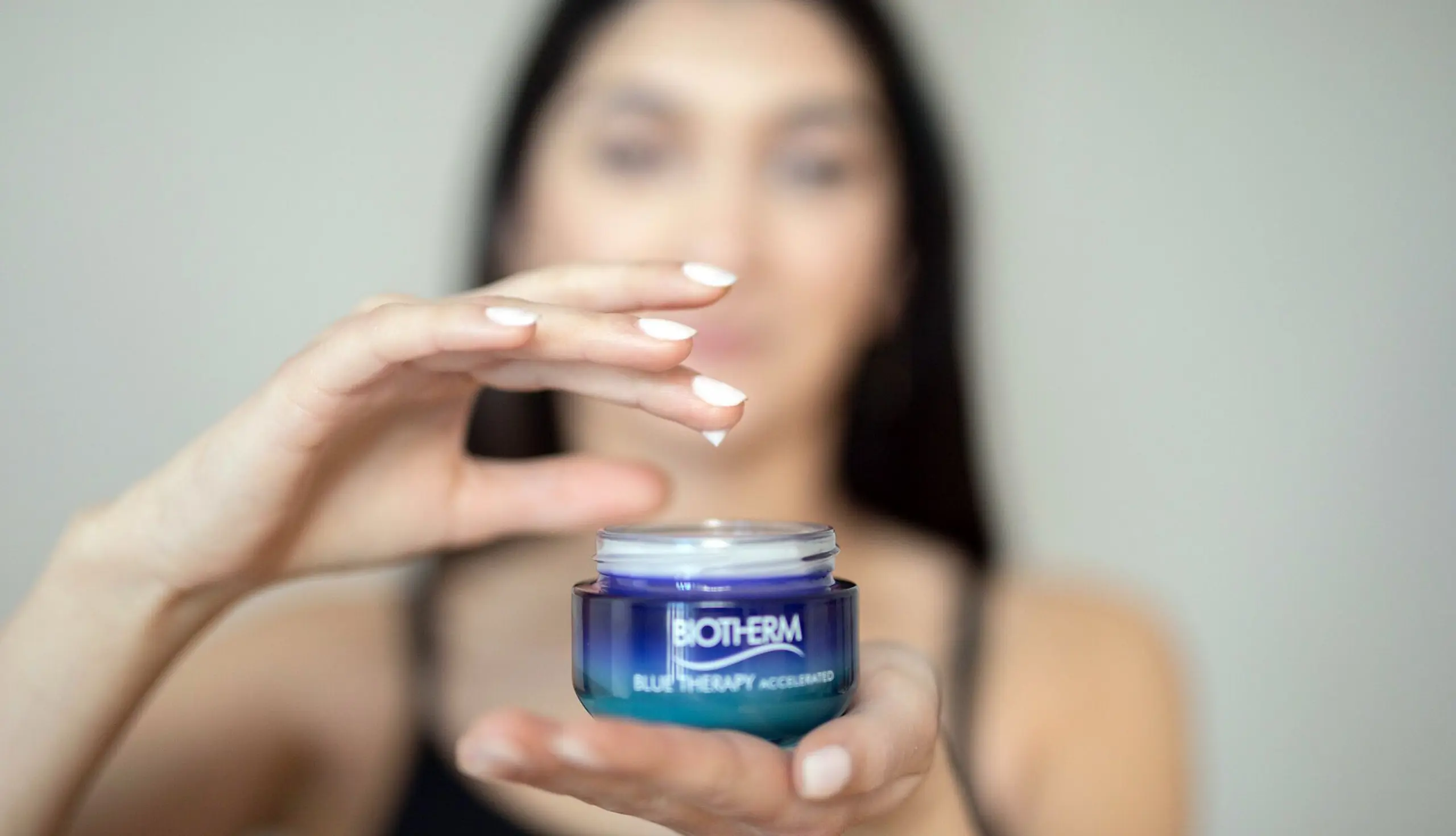 Kosmetikerin trägt Creme auf
