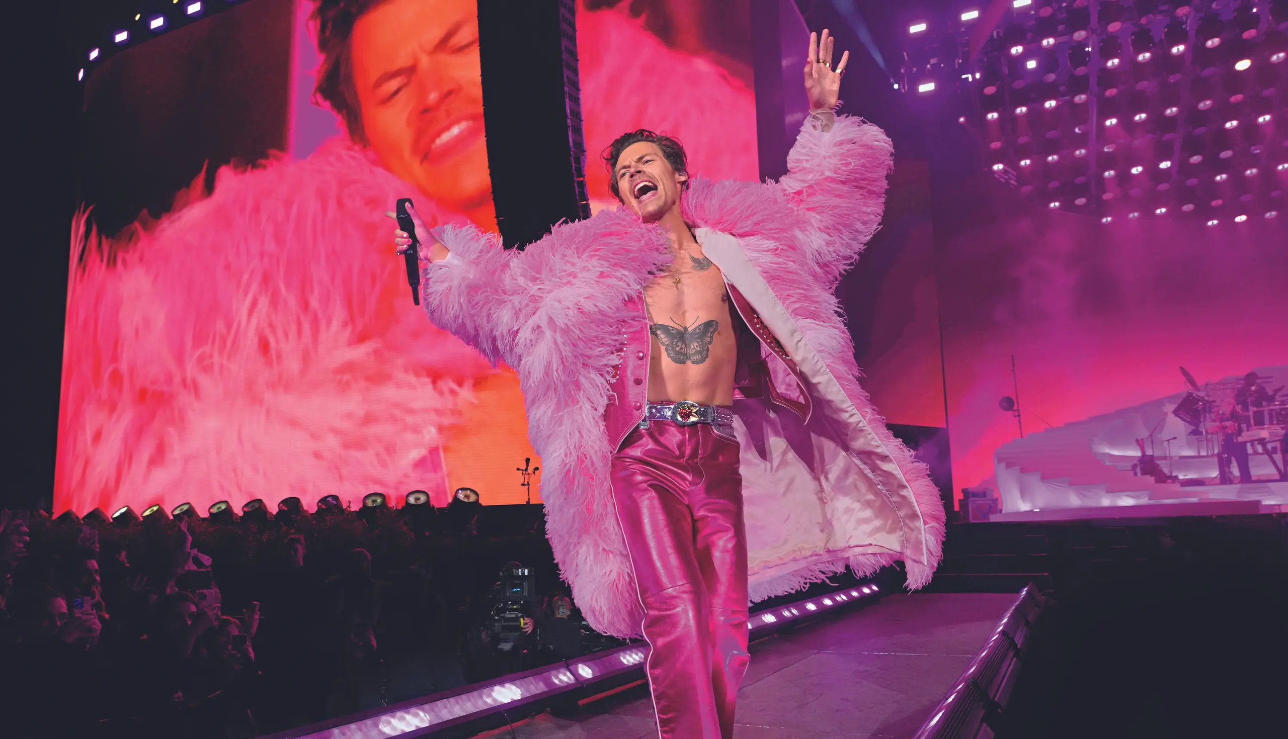 Harry Styles bei einem Konzert im pinken Plüschmantel