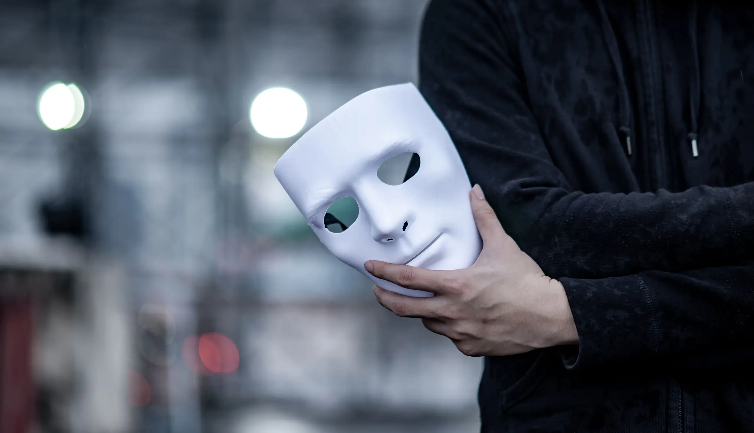 Mann hält Maske in der Hand