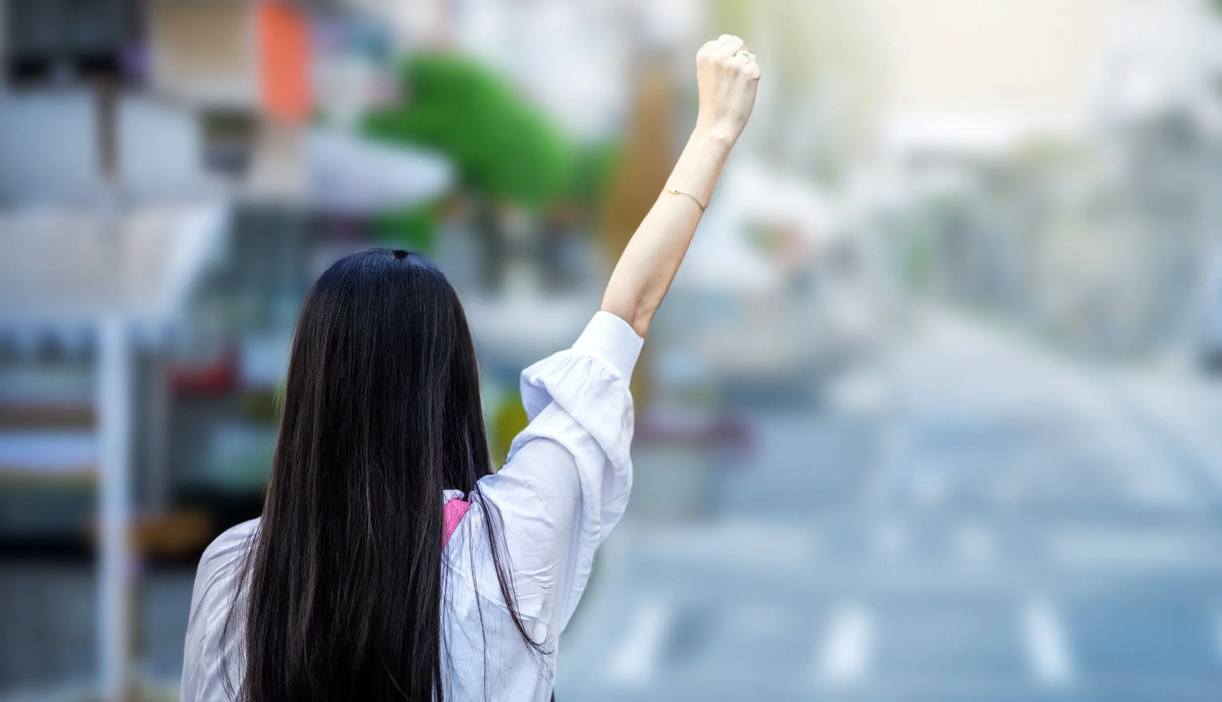 Woke, Wokeness - eine Frau ballt ihre Hand zu einer Faust und streckt sie in die Luft.
