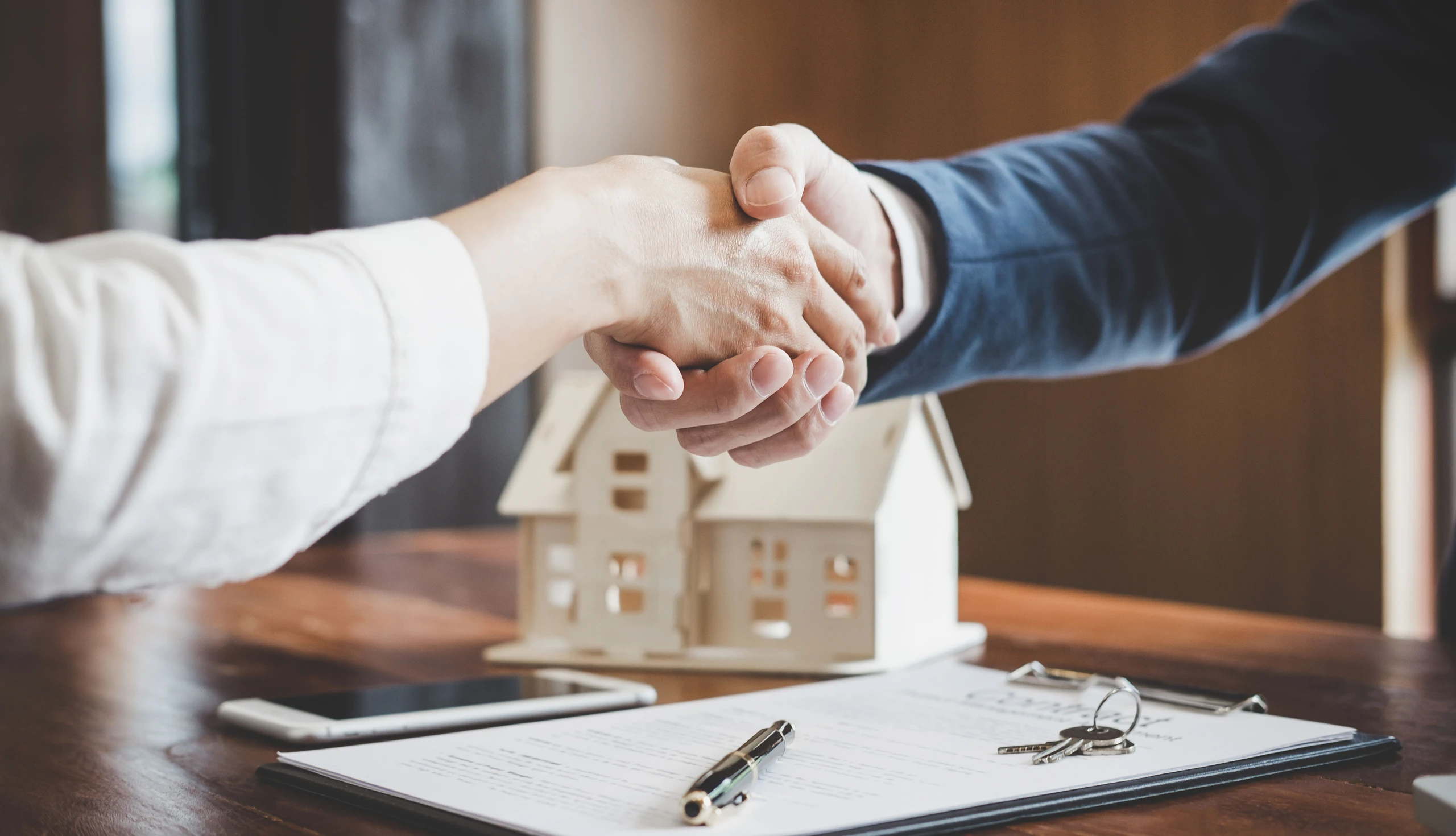 Kredit aufnehmen: Handschlag und Haus