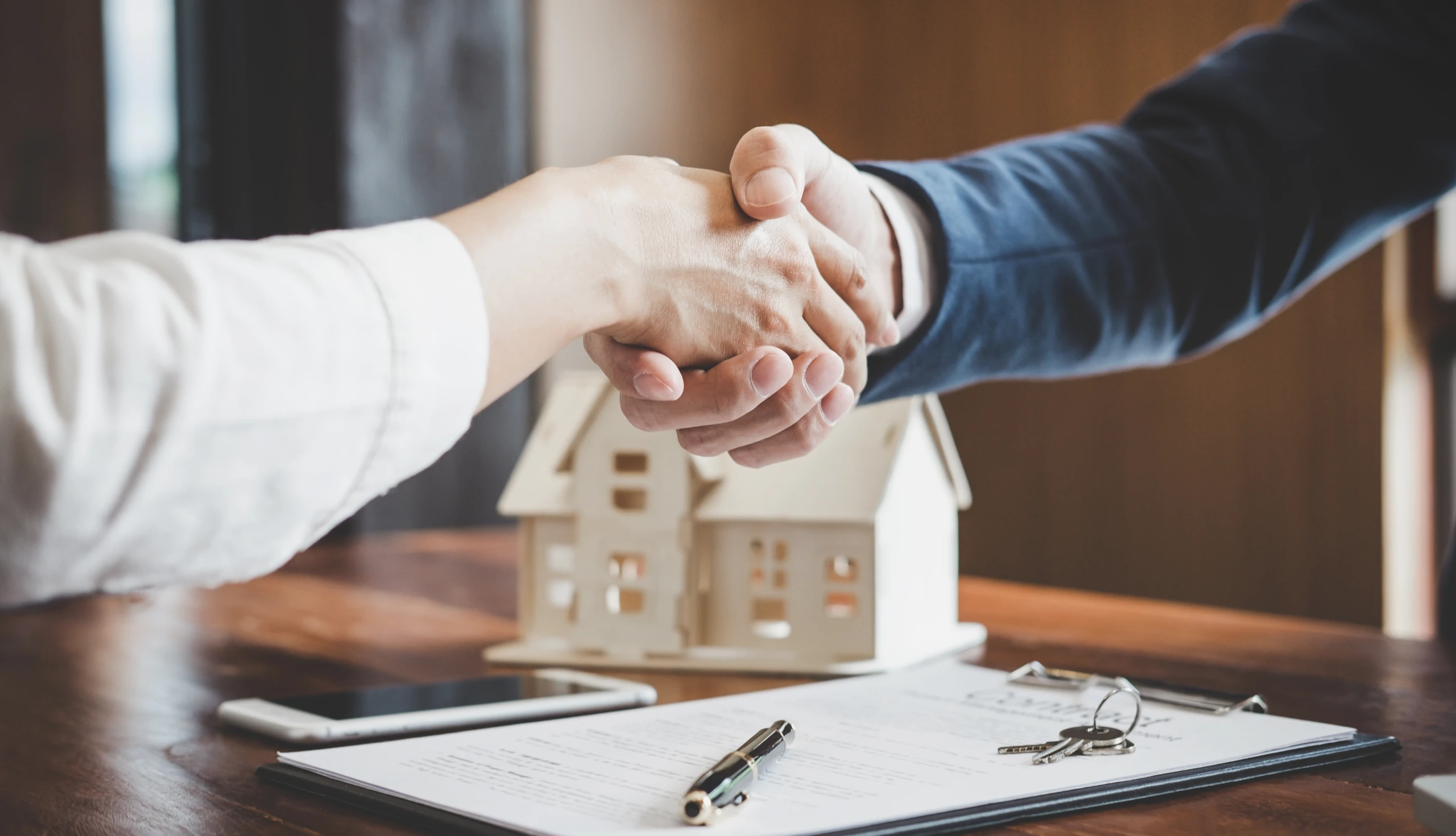 Kredit aufnehmen: Handschlag und Haus