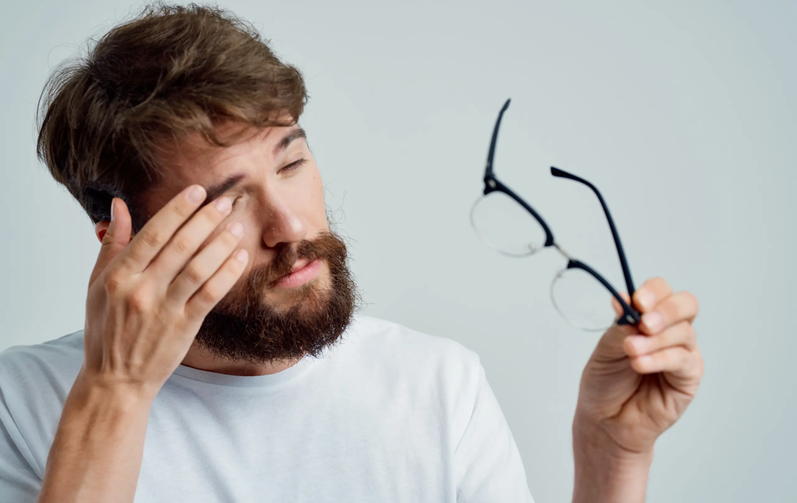 Ein Mann reibt sich das Auge.