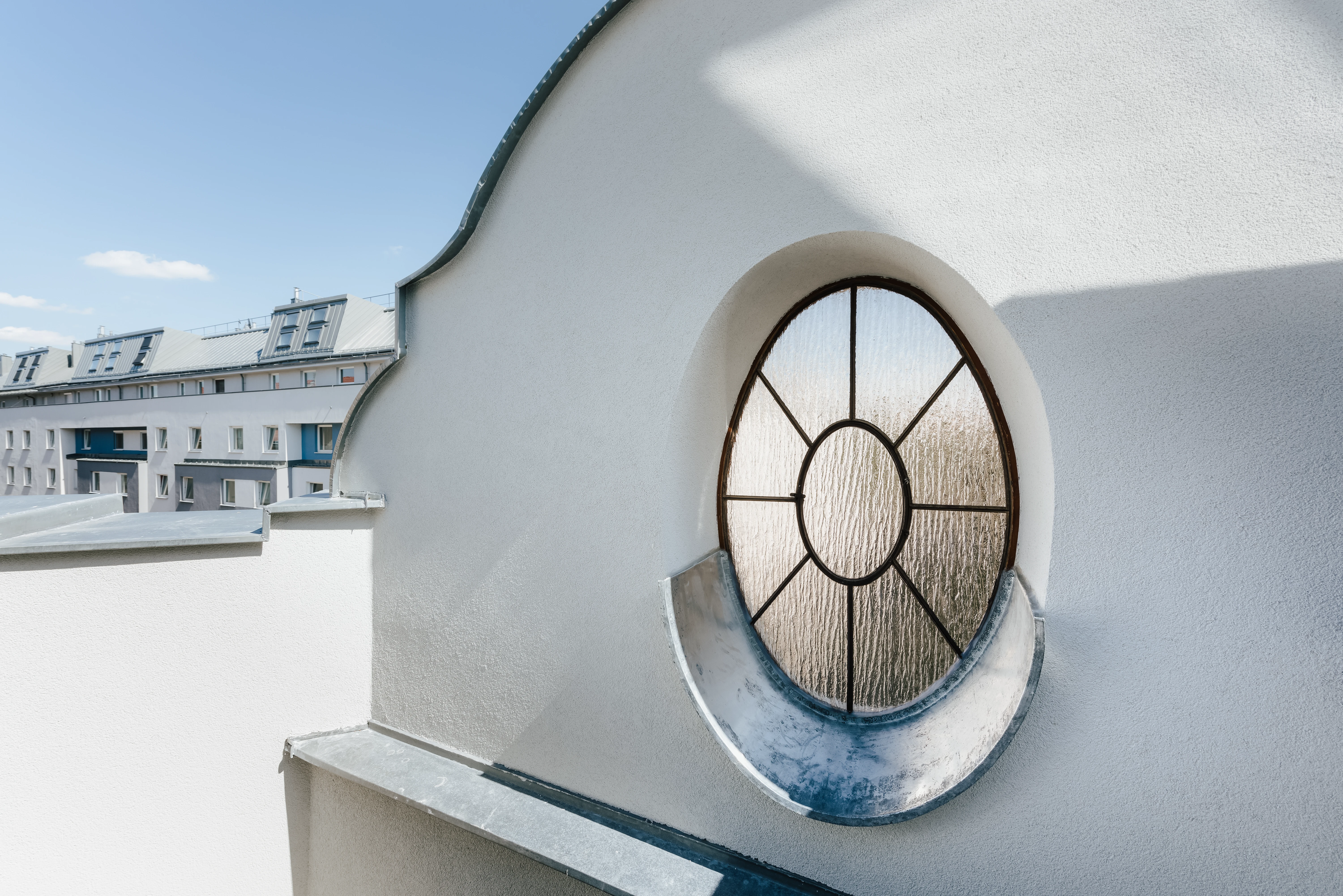 Rundes Fenster mit Metalldetails auf Dachterrasse