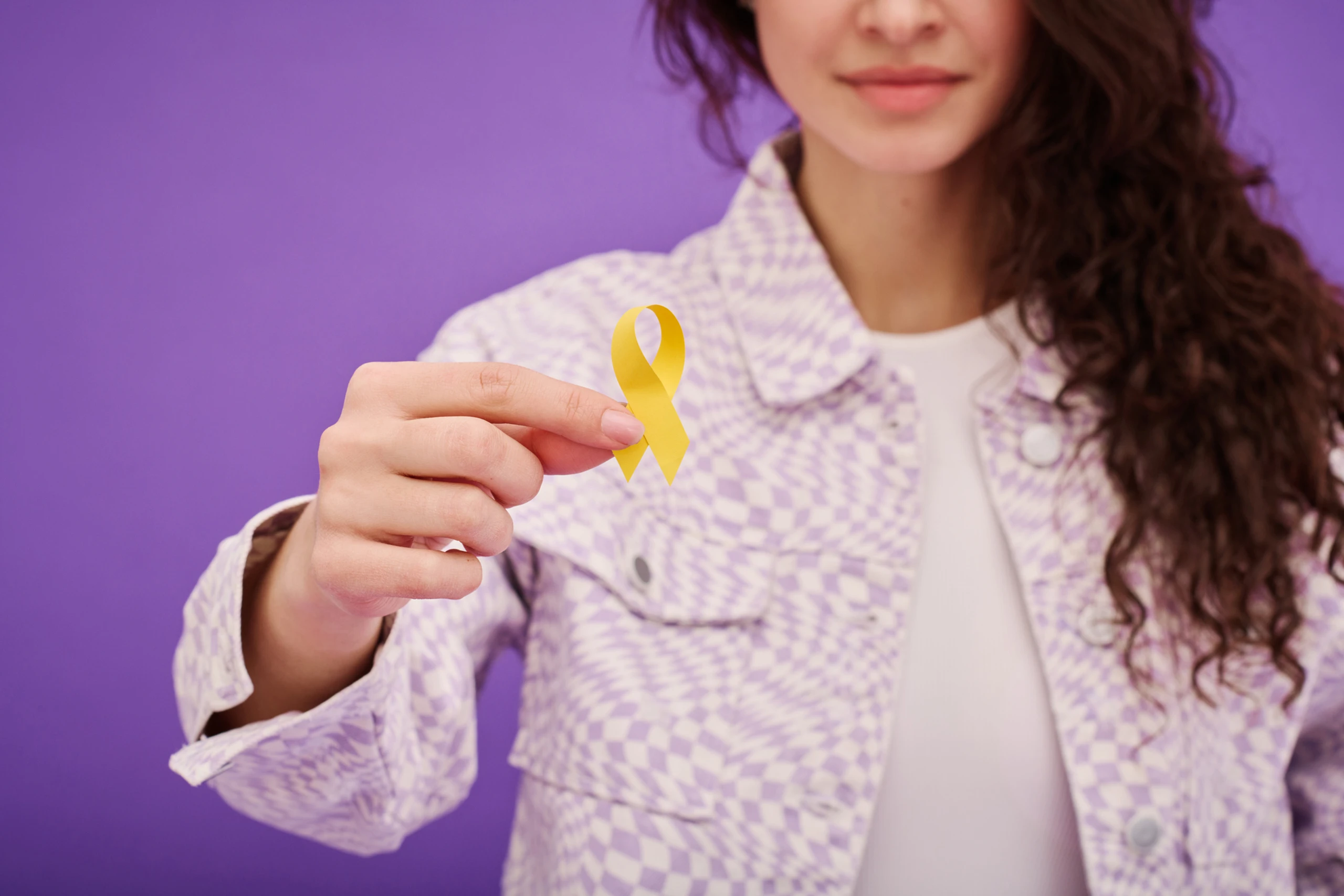 Frau, die eine gelbe Schleife hält